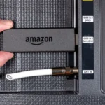Amazon Fire TV Stick cắm vào cổng HDMI của TV, cạnh dây ăng-ten bị cắt.