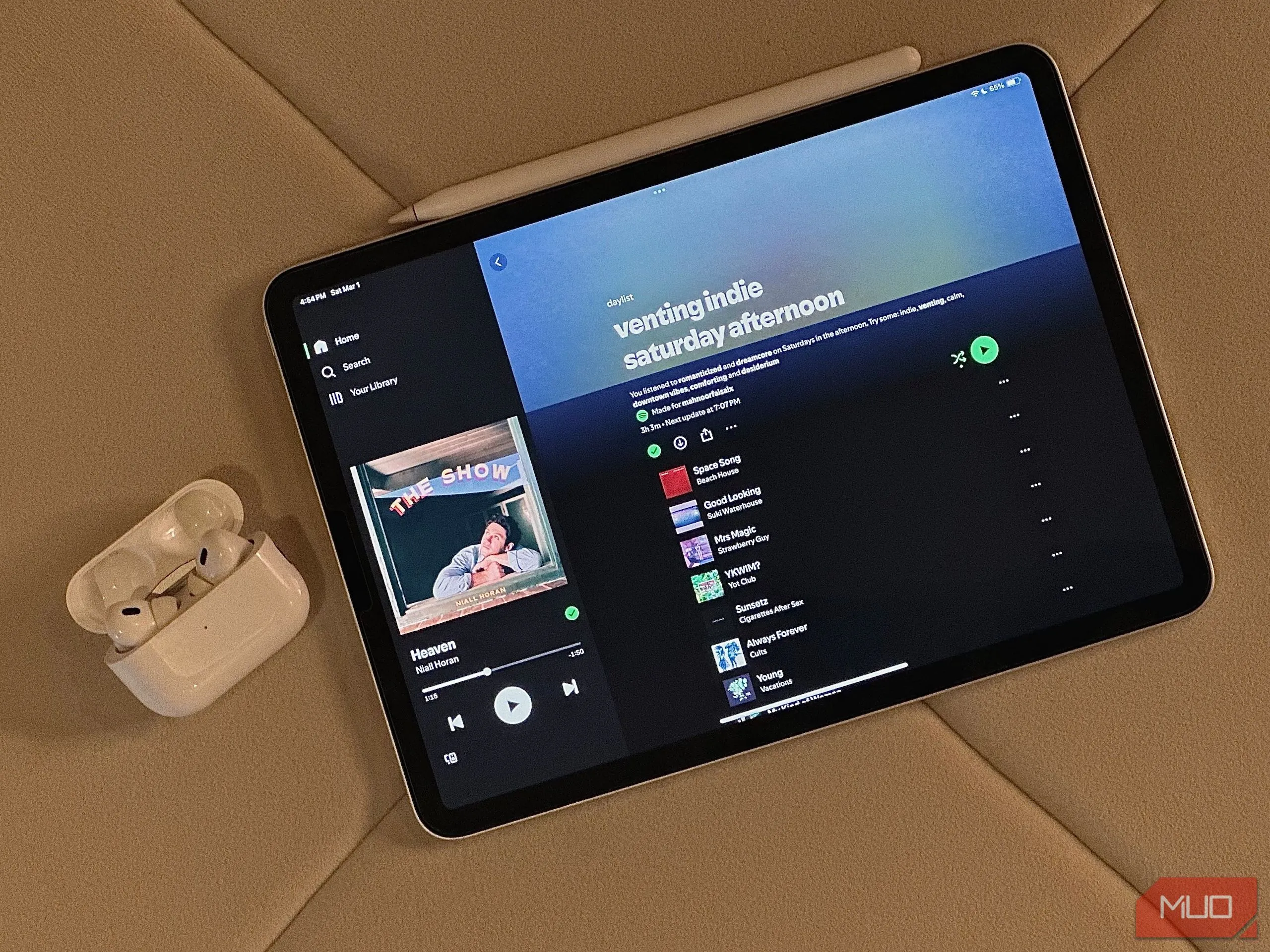 Ảnh gốc một chiếc iPad hiển thị ứng dụng Daylist, bên cạnh là hộp đựng tai nghe AirPods cần xóa