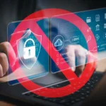 Bàn tay gõ laptop với biểu tượng bảo mật và dấu cấm màu đỏ, cảnh báo nguy cơ từ tiện ích mở rộng độc hại.