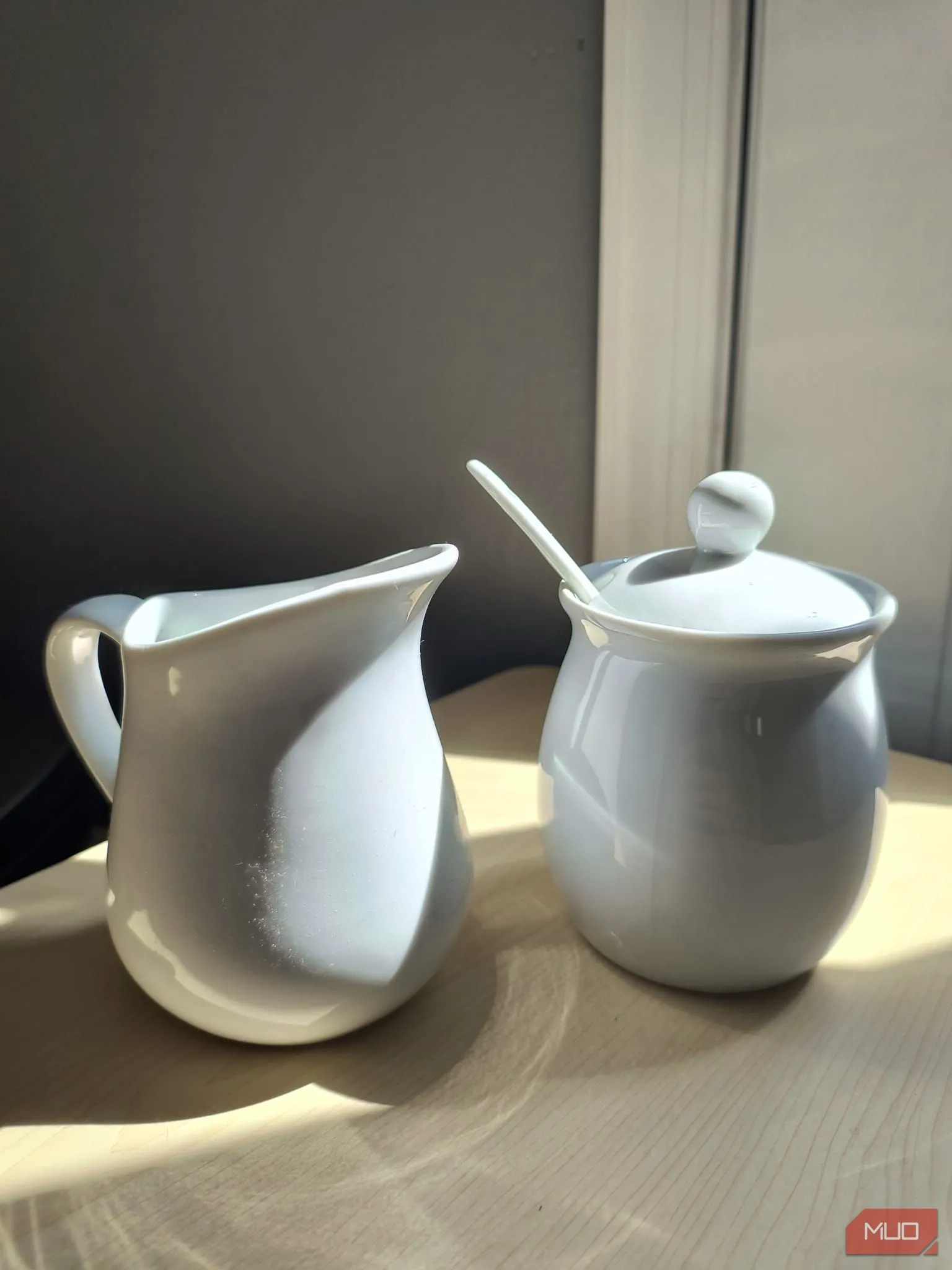 Bộ chén sứ trắng đặt dưới nắng gắt, phản chiếu cân bằng nhờ HDR