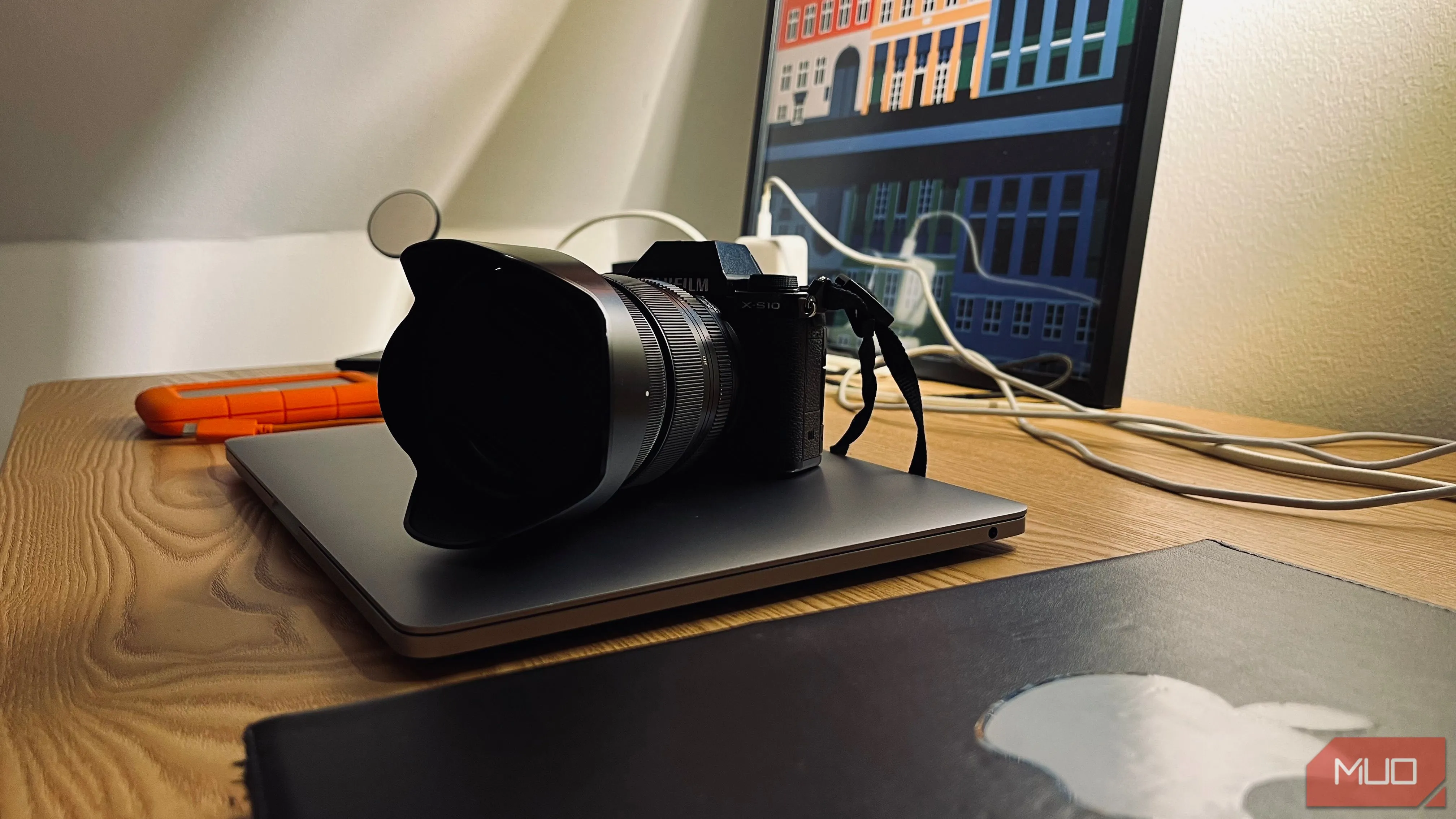 Bộ sưu tập thiết bị công nghệ gồm laptop, smartphone và máy ảnh xếp cạnh nhau trên bàn, minh họa việc chụp ảnh &quot;full setup&quot; tại nhà.
