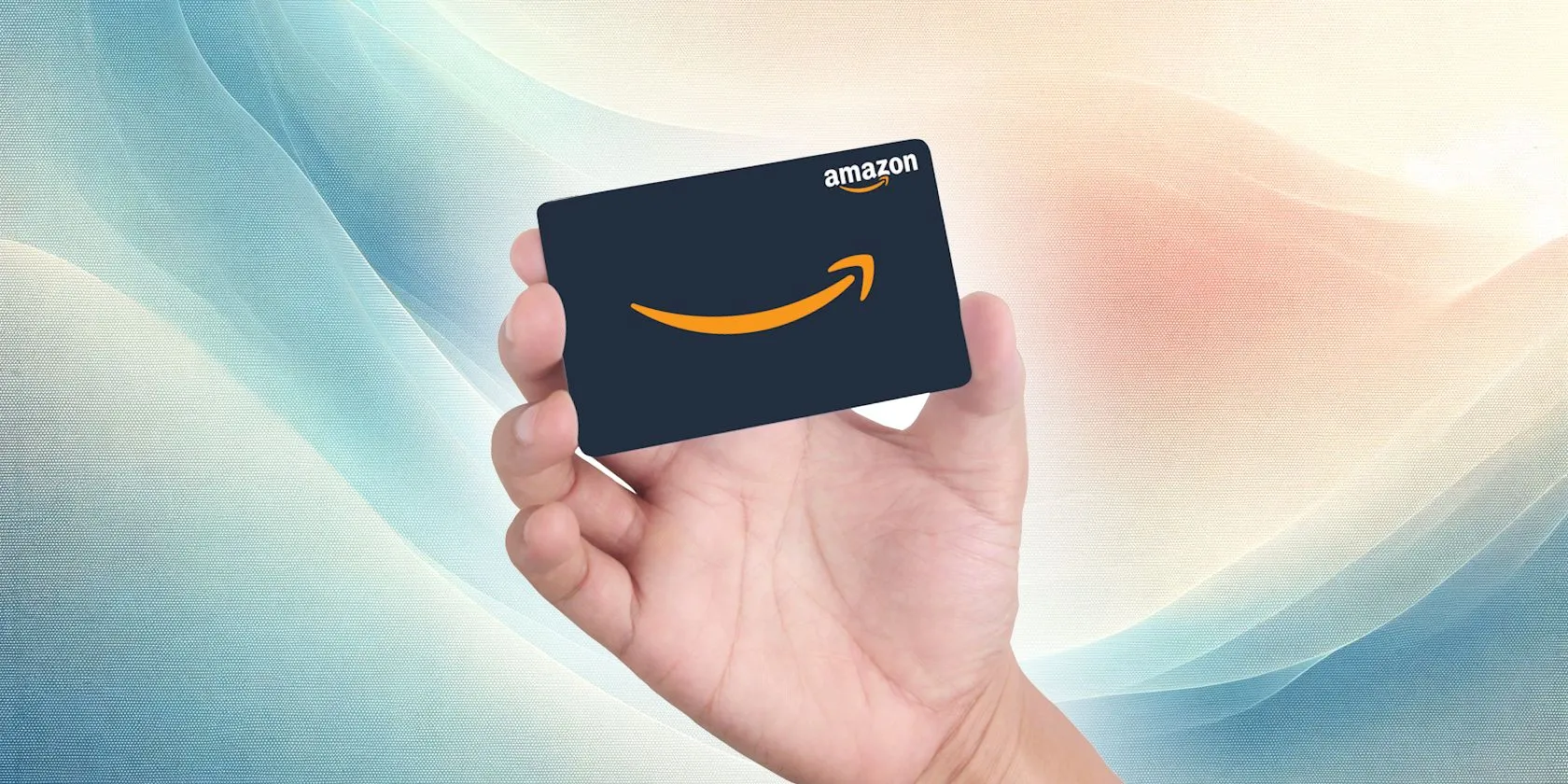 Cận cảnh bàn tay đang cầm thẻ quà tặng Amazon màu đen