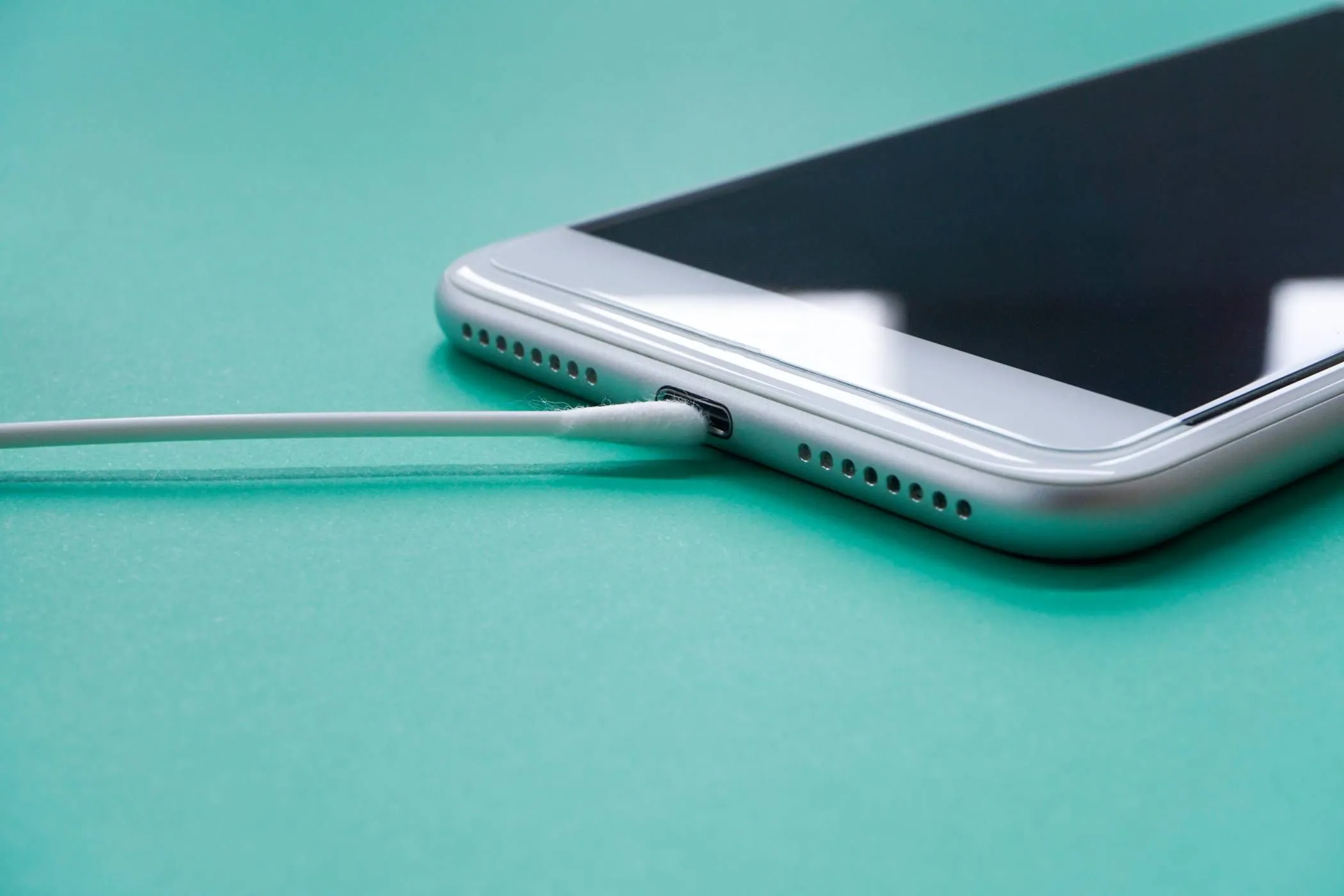 Cận cảnh cổng sạc điện thoại Samsung đang được làm sạch bằng tăm bông để loại bỏ độ ẩm