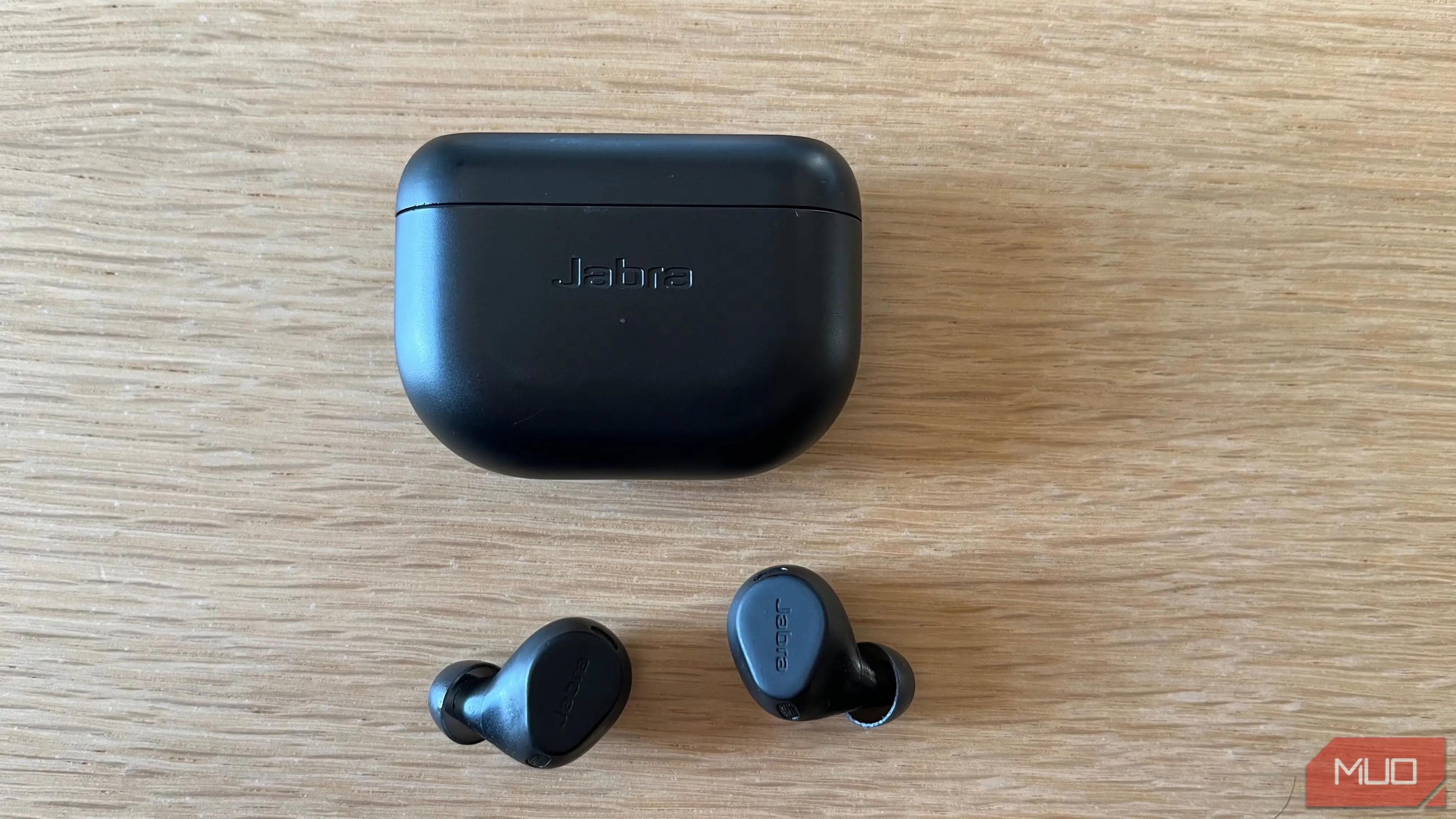 Cặp tai nghe không dây Jabra Elite 8 Active đặt trên bàn gỗ, minh họa thiết bị giúp tập trung làm việc bằng cách loại bỏ tiếng ồn.