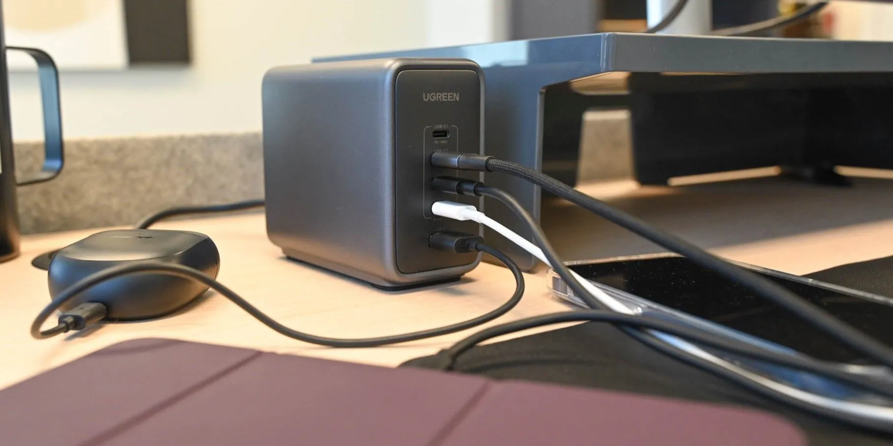 Củ sạc Ugreen Nexode 300W màu xám với nhiều cổng USB-C đang kết nối sạc cho bốn thiết bị cùng lúc, thể hiện khả năng quản lý nhiệt và sạc hiệu quả của sạc có dây.