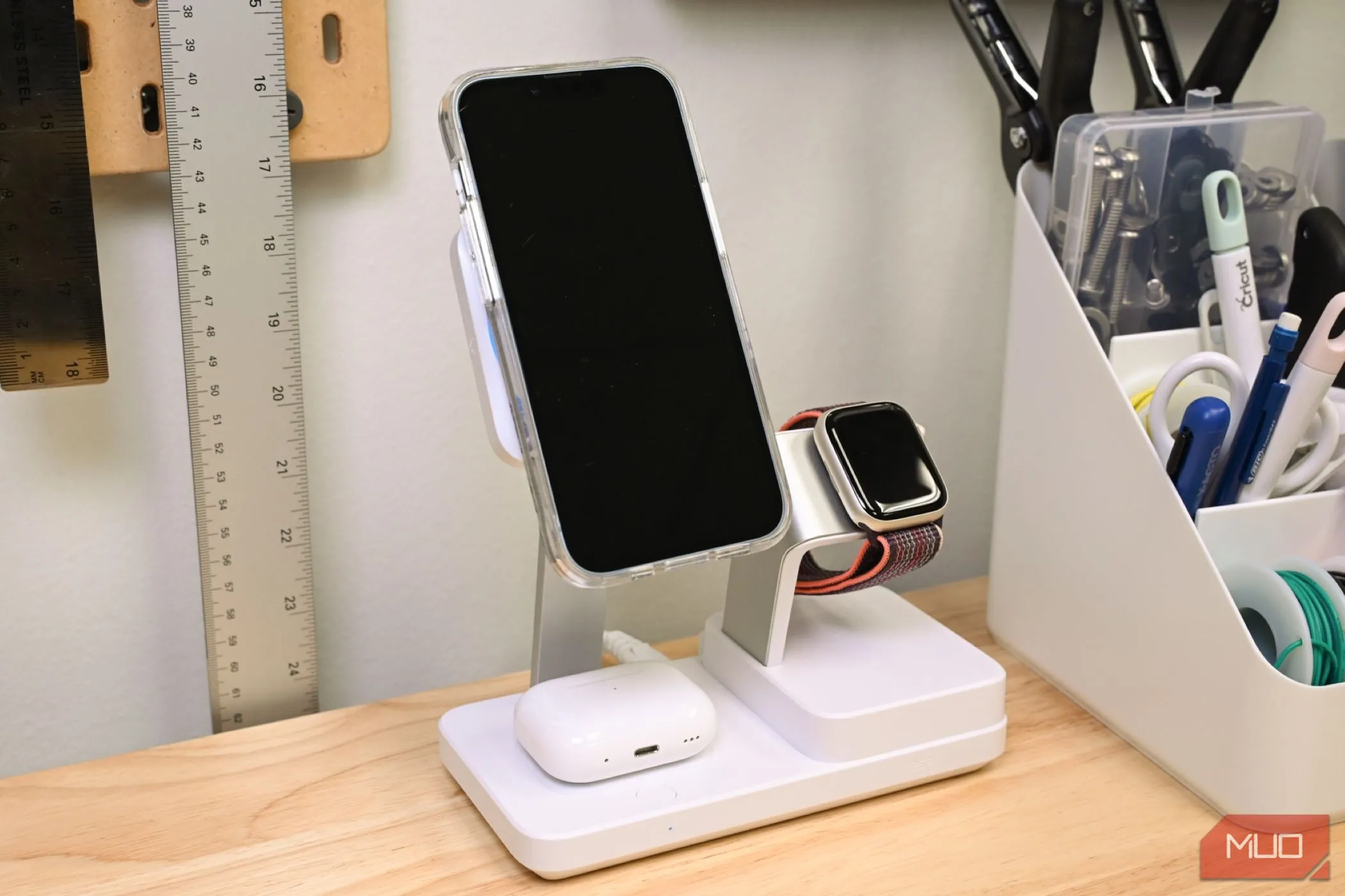 Điện thoại iPhone, tai nghe AirPods và đồng hồ Apple Watch đang sạc trên đế sạc không dây đa năng ESR 100W, minh họa tính năng sạc từ tính MagSafe và Qi2.