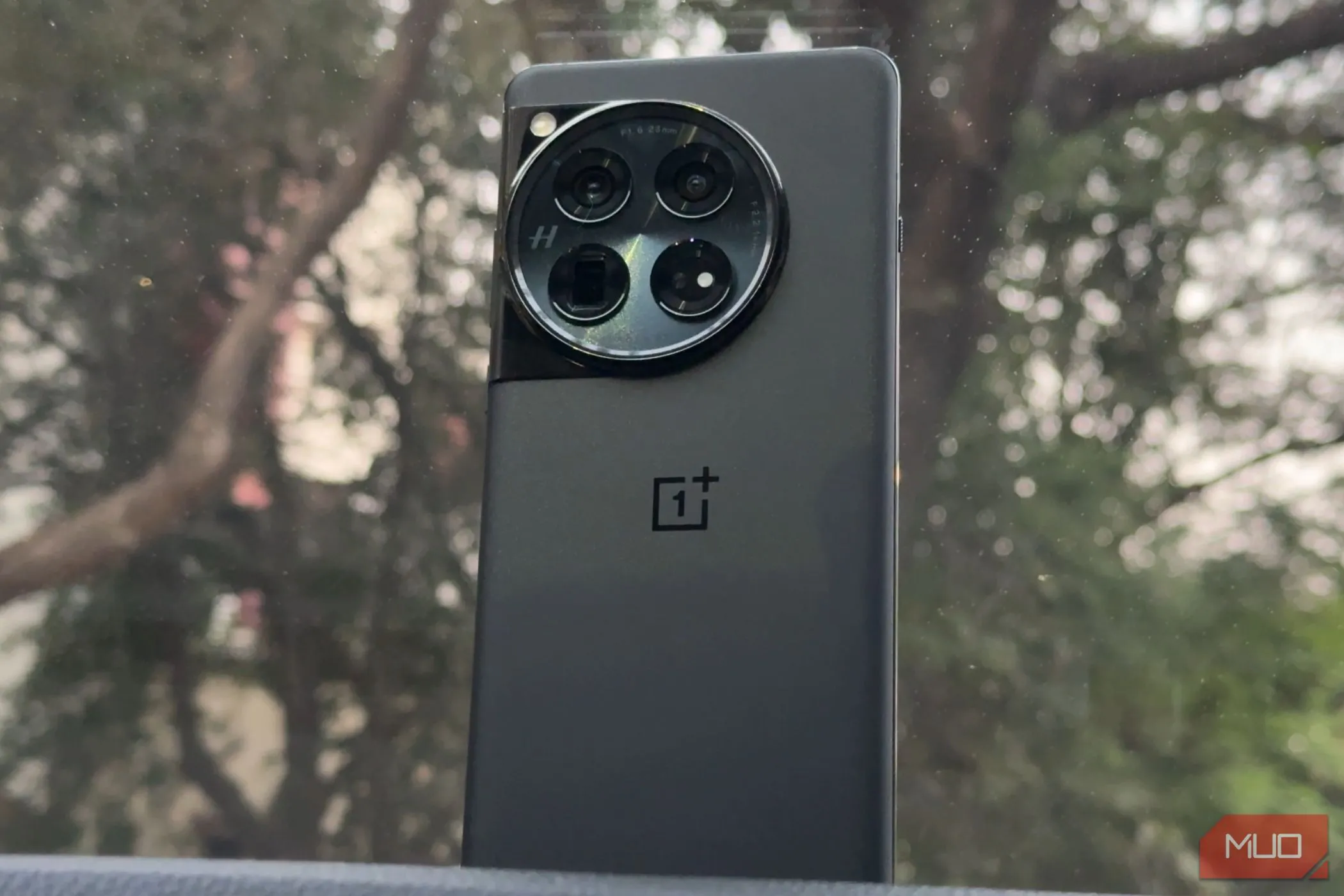 Điện thoại OnePlus 12 màu đen đặt trên bảng điều khiển xe ô tô, thể hiện sự sang trọng và tiện dụng.