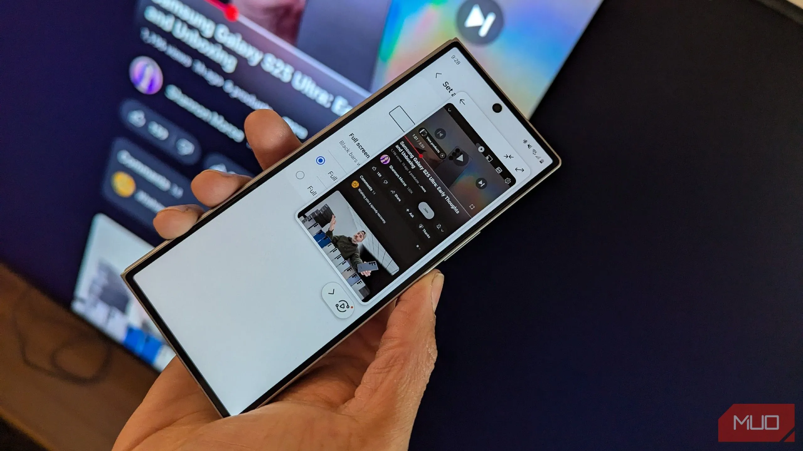 Điện thoại Samsung Galaxy đang chạm vào cạnh của TV Samsung để kích hoạt tính năng Tap View, phản chiếu màn hình.
