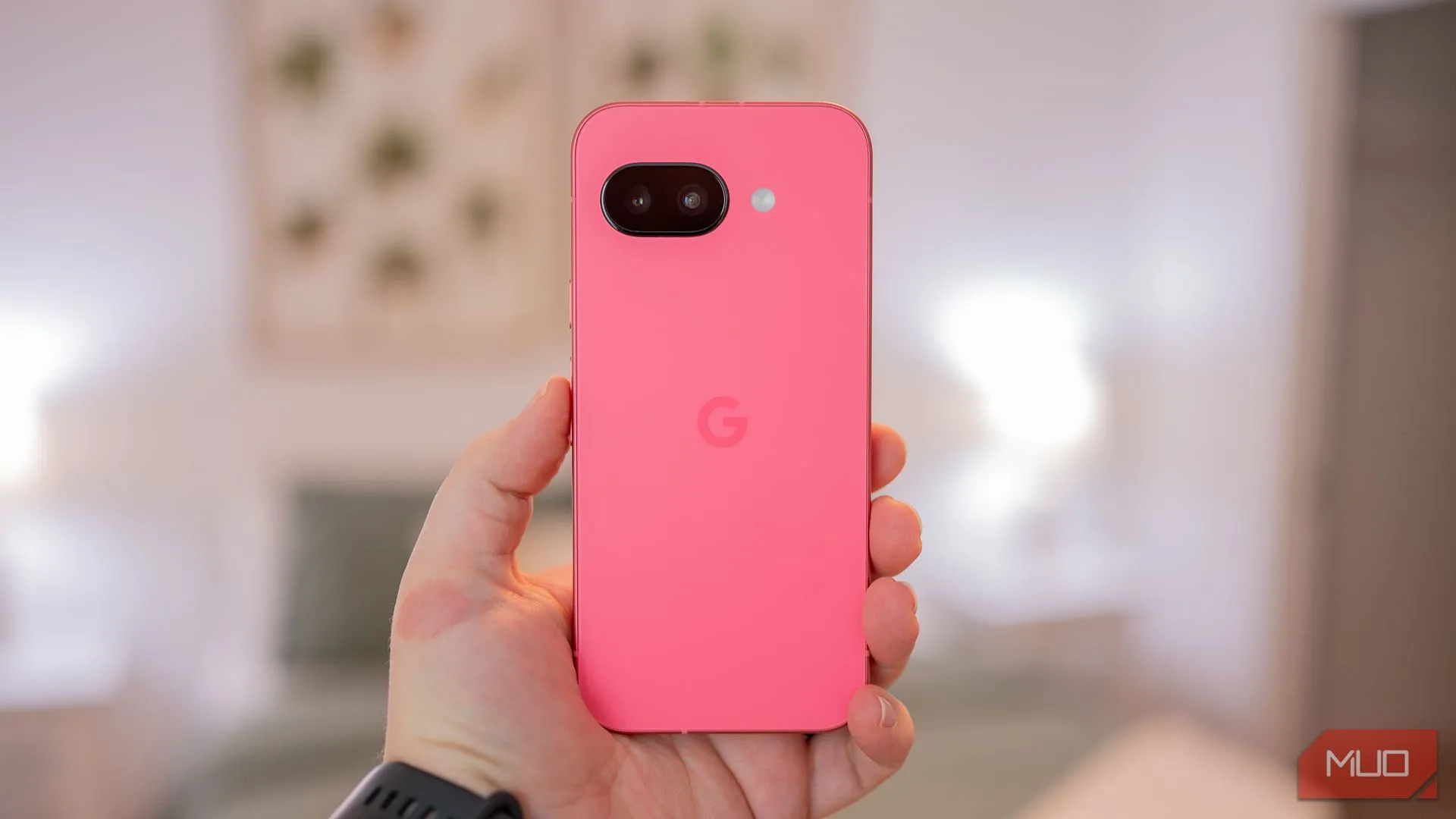 Hình ảnh một người đang cầm Google Pixel 9a, cho thấy thiết kế mặt lưng tối giản với lớp hoàn thiện mờ và khung kim loại sang trọng.
