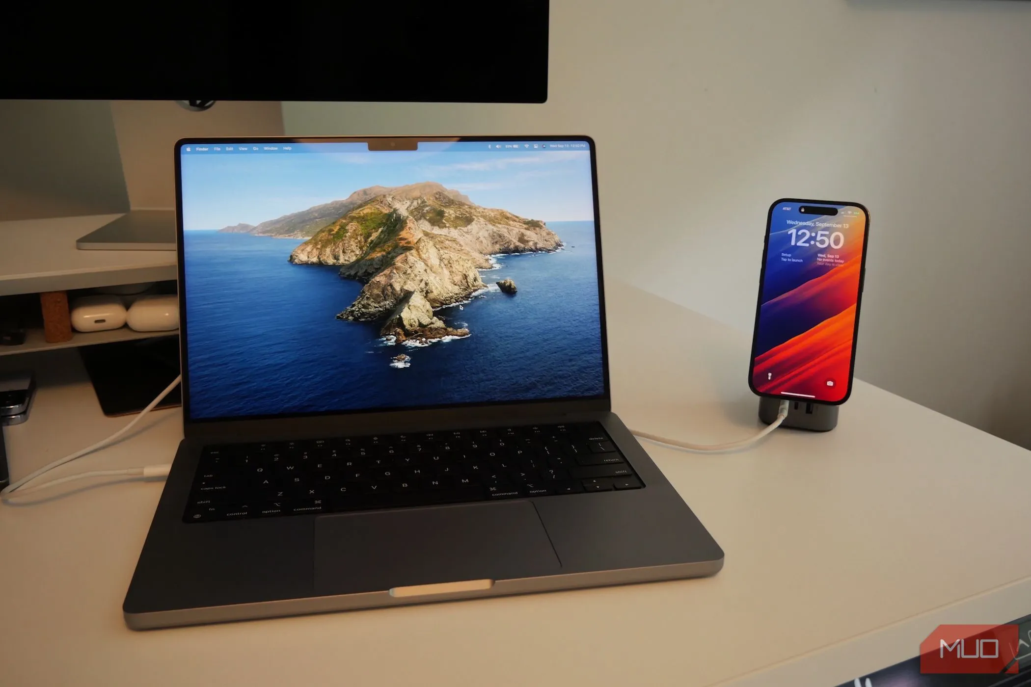 iPhone và MacBook Pro đang sạc, minh họa việc sử dụng iPhone làm loa ngoài cho Mac