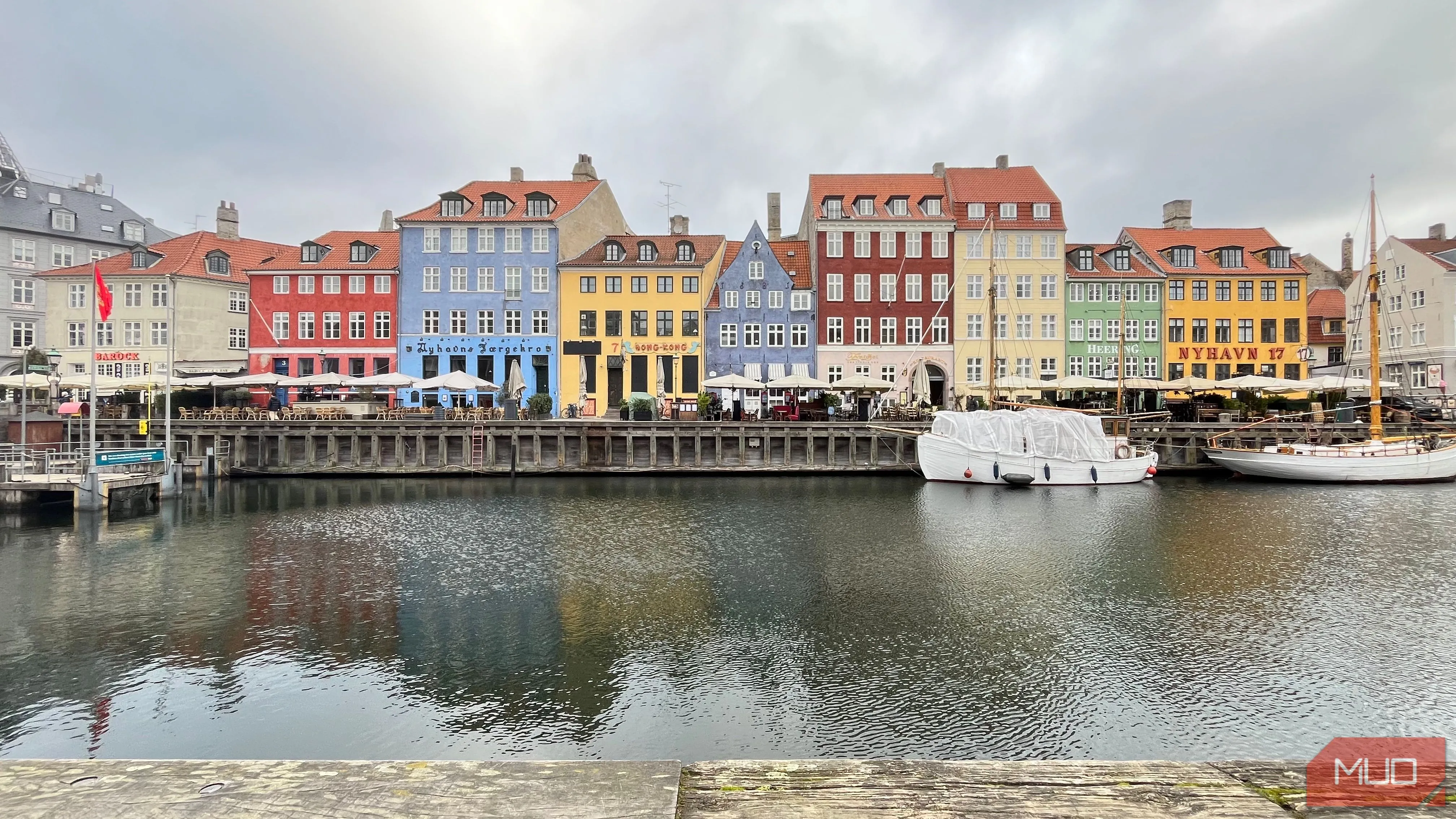 Kênh đào Nyhavn với những ngôi nhà cổ nhiều màu sắc dưới bầu trời u ám tại Copenhagen