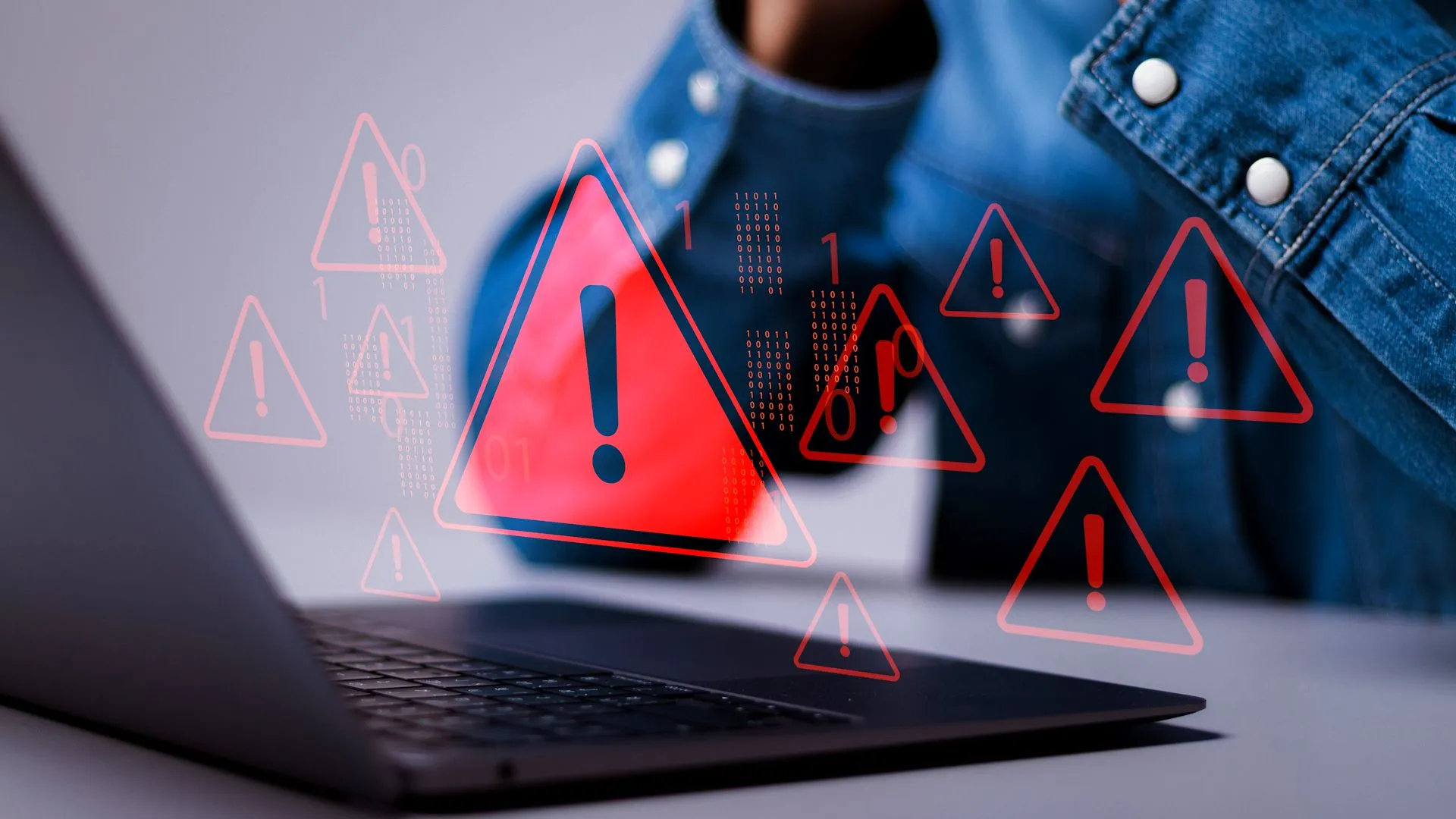 Laptop hiển thị cảnh báo vi phạm dữ liệu với biểu tượng tam giác đỏ, minh họa nguy cơ tấn công ransomware hoặc mất an toàn thông tin khi sử dụng các công cụ chuyển đổi file không đáng tin cậy.