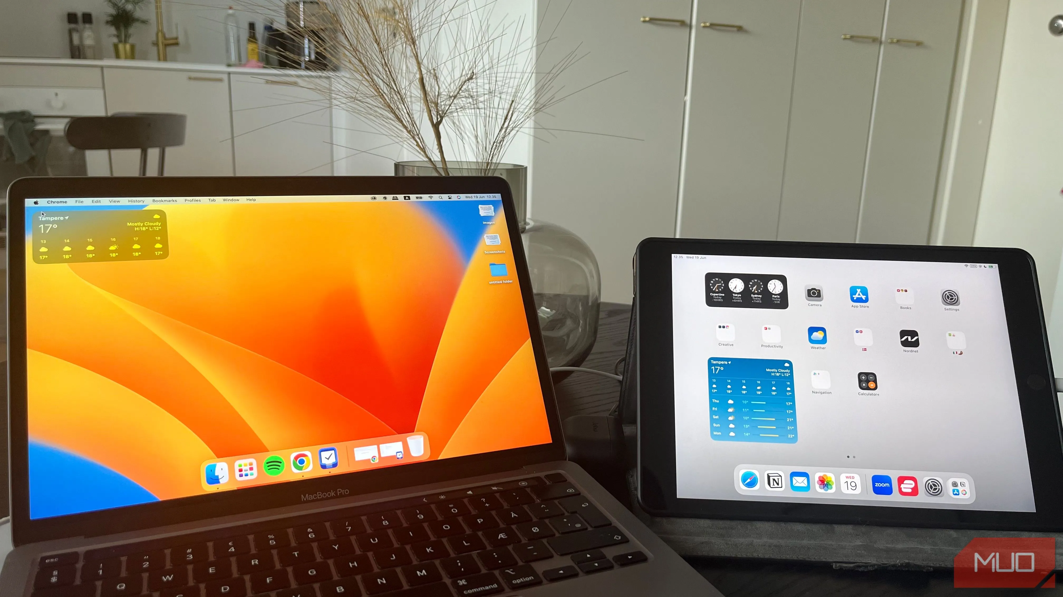 Laptop MacBook Pro và máy tính bảng iPad cạnh nhau trên bàn gỗ, gợi ý cách sắp xếp thiết bị công nghệ để chụp ảnh làm việc.