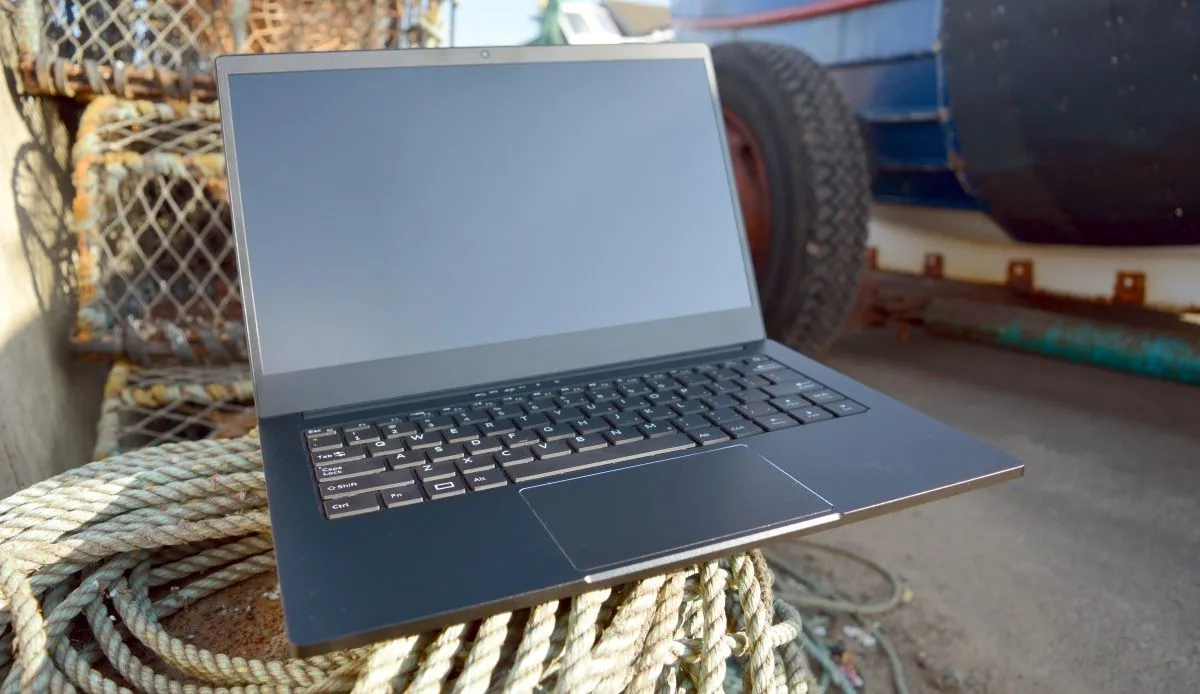 Laptop Purism Librem với thiết kế chắc chắn, đặt cạnh một chiếc xe nông nghiệp, thể hiện sự bền bỉ.