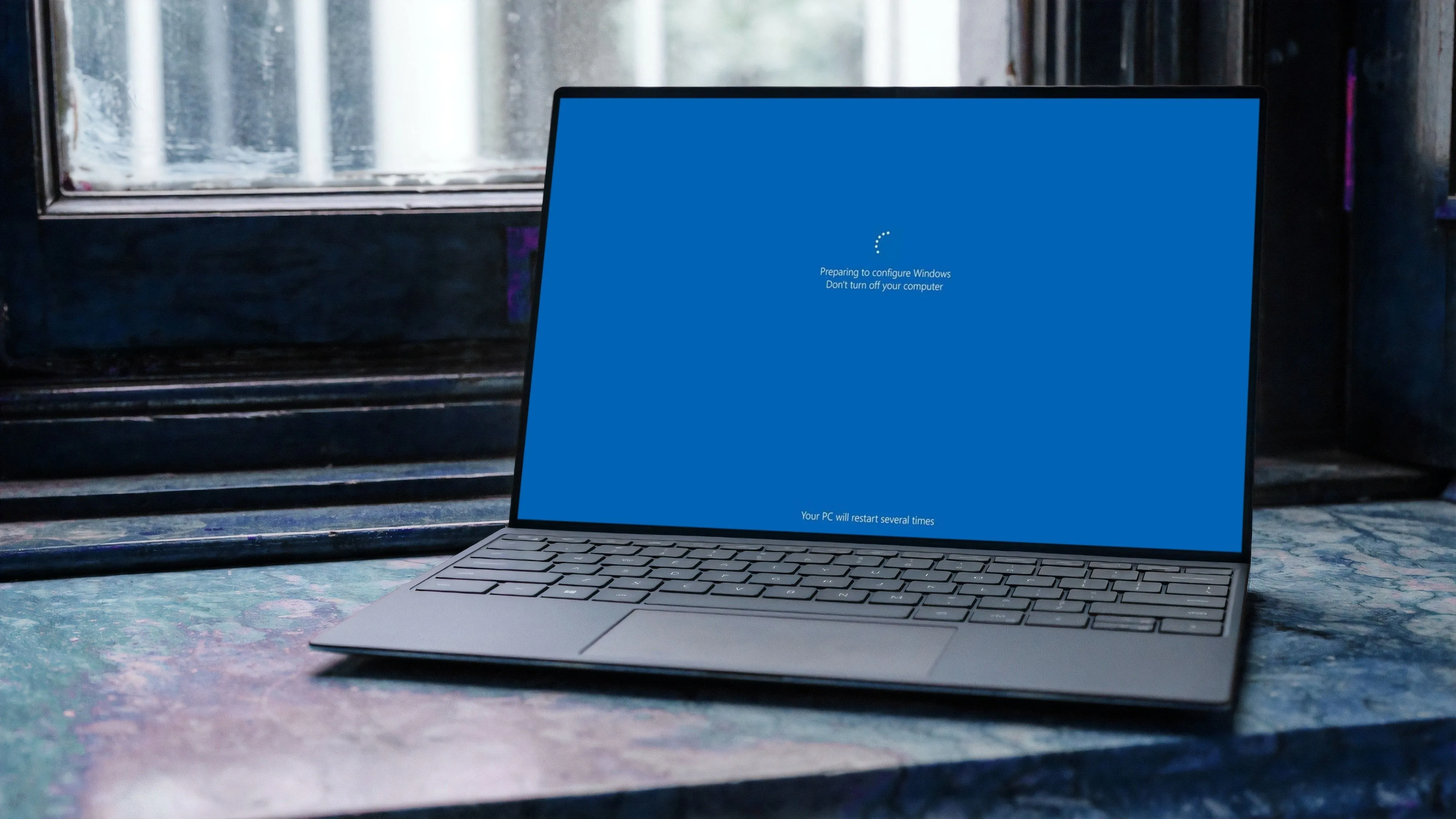 Laptop Windows 11 đang hiển thị màn hình cập nhật, thể hiện quá trình cài đặt bản vá hệ thống.
