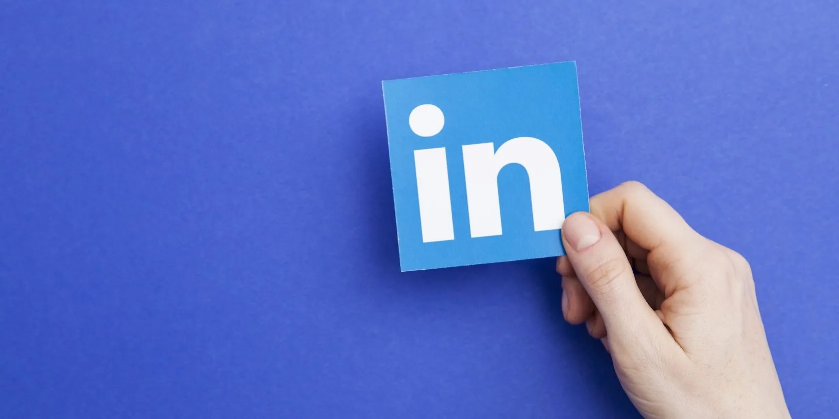 Logo LinkedIn quen thuộc trên tay người dùng, thể hiện ứng dụng mạng xã hội chuyên nghiệp với chính sách dữ liệu liên quan đến AI.
