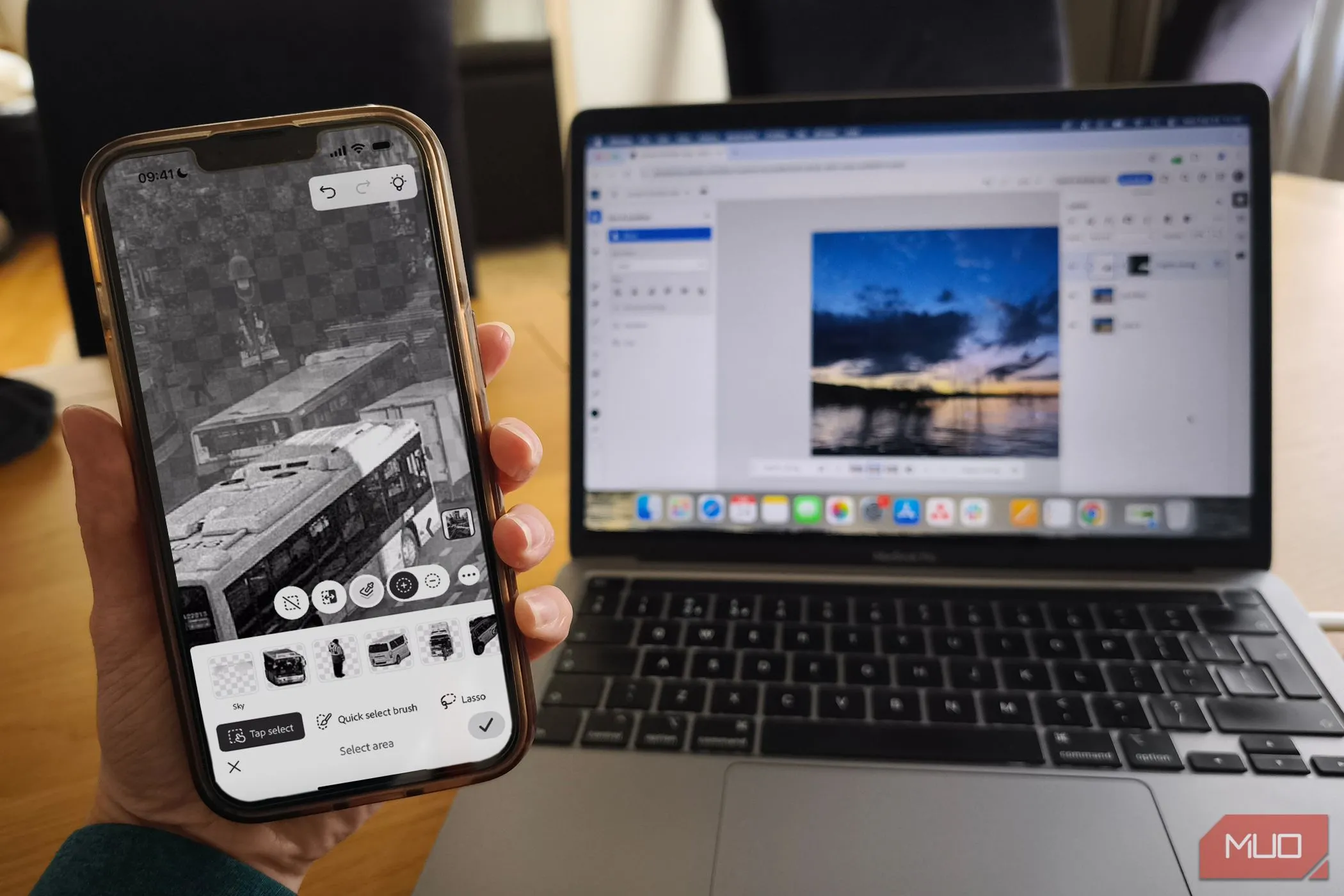 MacBook hiển thị Photoshop trên nền web và iPhone cài đặt ứng dụng Photoshop Mobile
