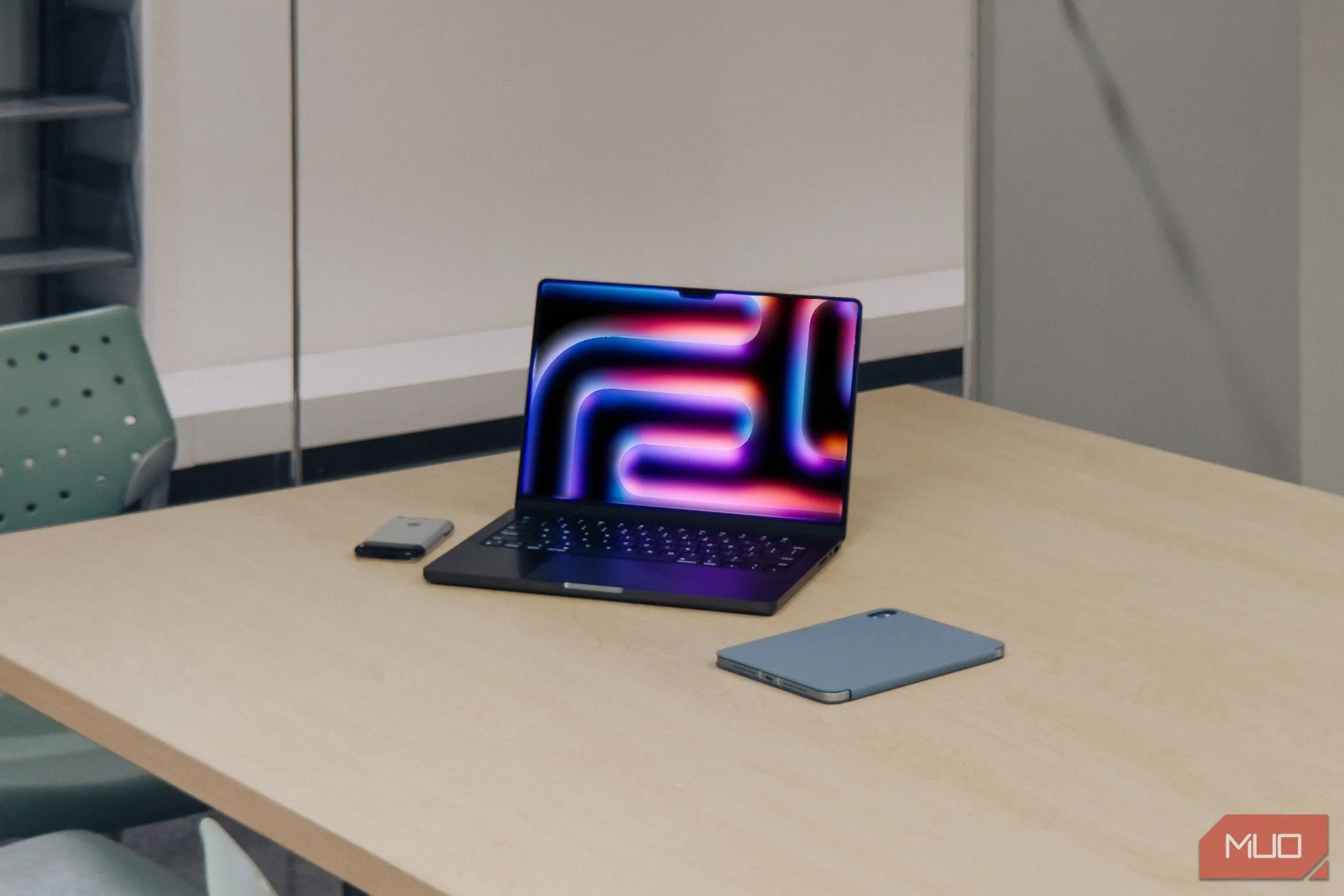 MacBook Pro M4 cùng iPad và iPhone 2G trên bàn gỗ