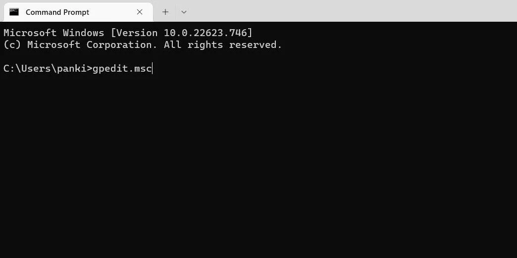Màn hình Command Prompt hoặc PowerShell hiển thị lệnh 'gpedit.msc' đã được nhập và thực thi để mở Group Policy Editor