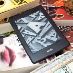 Máy đọc sách Kindle nằm trên chồng sách giấy truyền thống