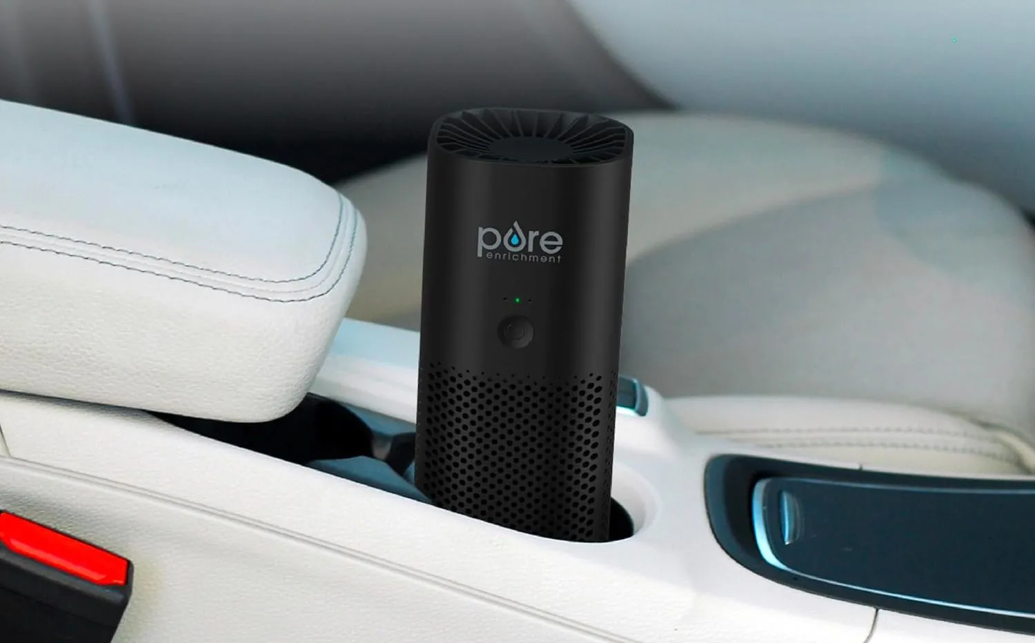 Máy lọc không khí di động PureZone Mini từ Pure Enrichment đặt trong hốc đựng cốc ô tô.