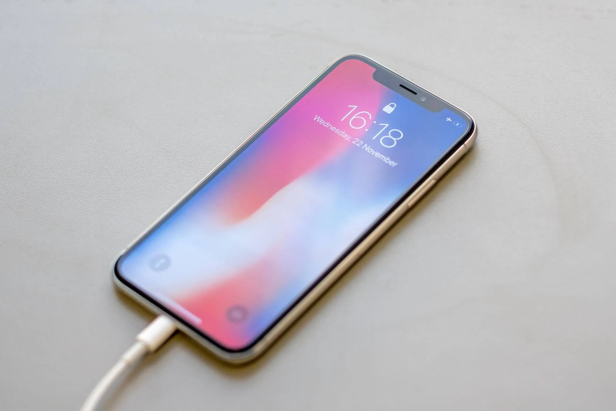 Một chiếc iPhone đang cắm sạc bằng cáp, minh họa cho việc sạc qua đêm với công nghệ tối ưu pin.