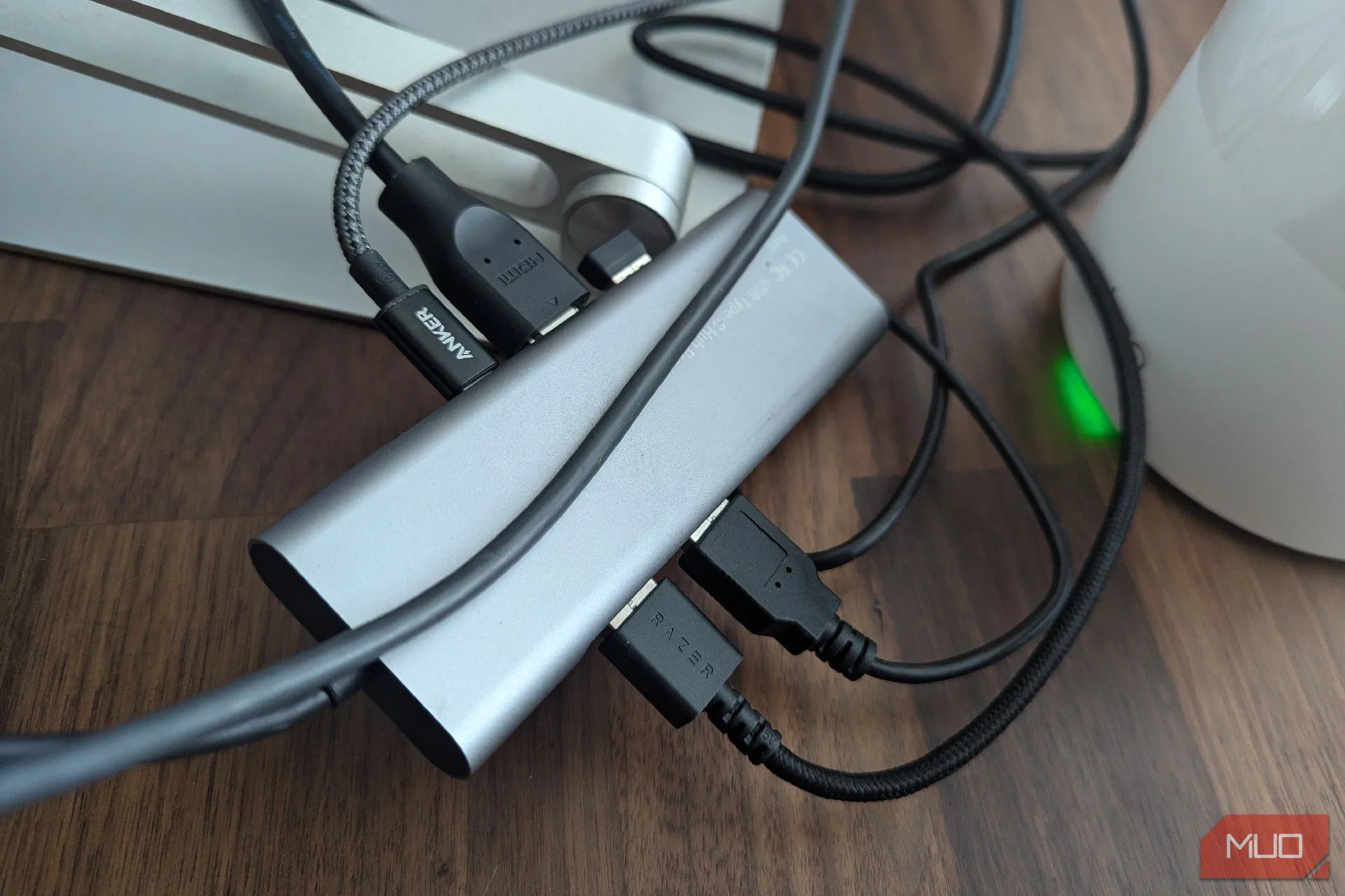 Một dock USB-C truyền thống với nhiều cáp kết nối lộn xộn, thể hiện vấn đề về sự gọn gàng trên bàn làm việc.