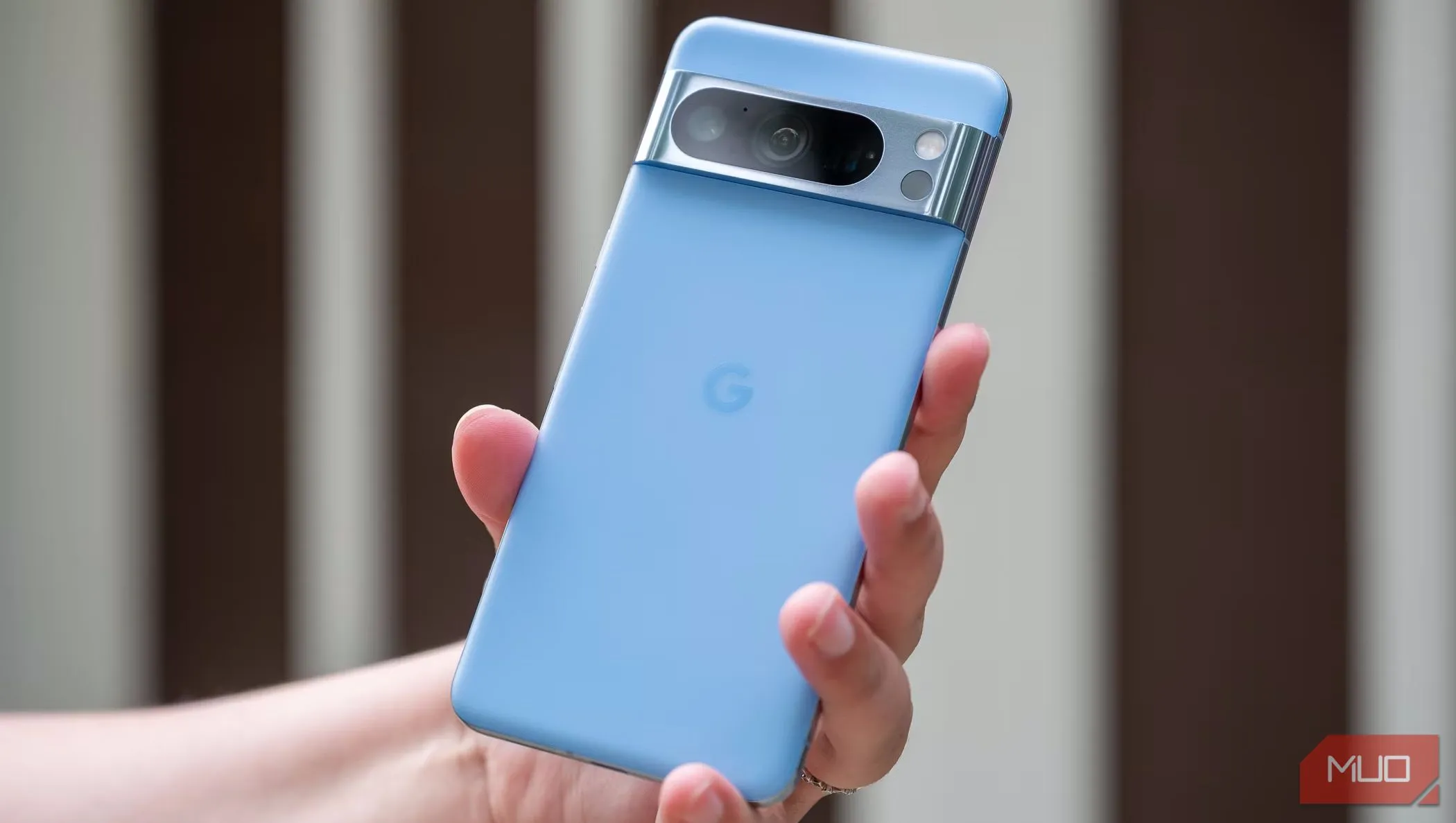 Một người đàn ông đang cầm Pixel 8 Pro và cho thấy mặt lưng của nó