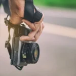 Một người đang cầm máy ảnh mirrorless chụp ảnh, minh họa cho sự phát triển của công nghệ nhiếp ảnh số và sự khác biệt với máy ảnh compact.