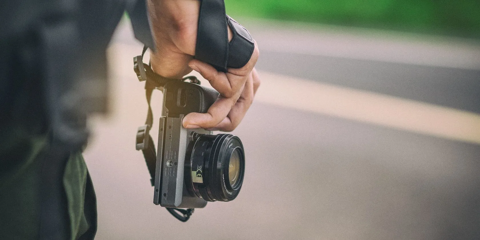 Một người đang cầm máy ảnh mirrorless chụp ảnh, minh họa cho sự phát triển của công nghệ nhiếp ảnh số và sự khác biệt với máy ảnh compact.