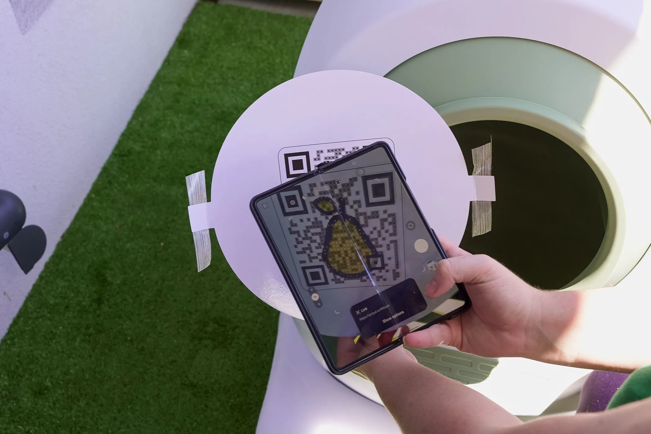 Một người dùng đang quét mã QR trong không gian công cộng, nhấn mạnh tầm quan trọng của việc kiểm tra ngữ cảnh để phát hiện mã QR giả mạo.
