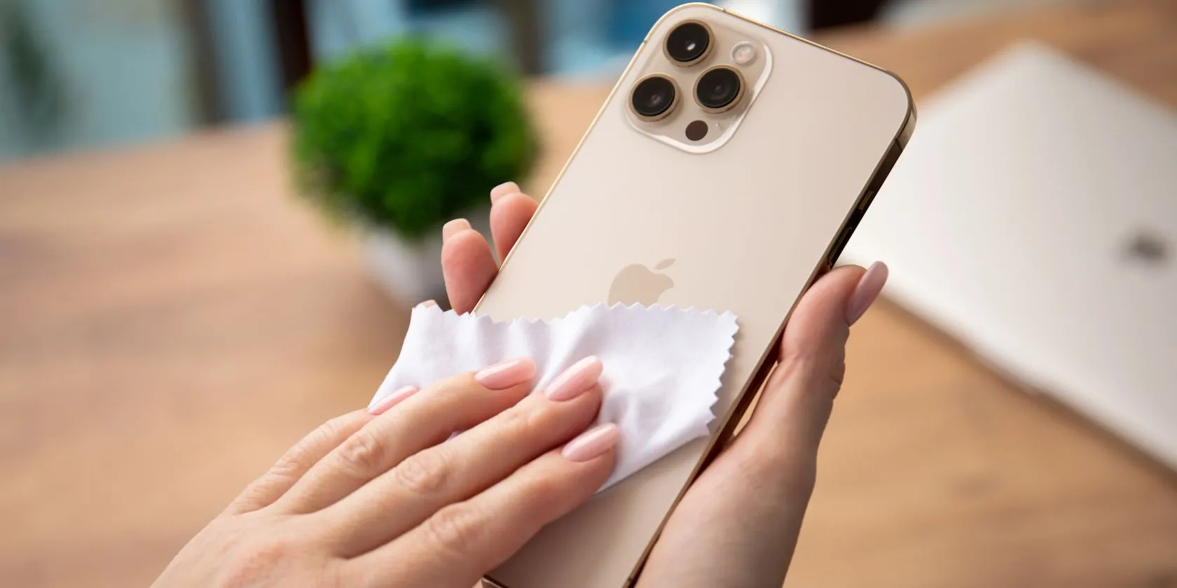 Một người phụ nữ đang lau iPhone bằng khăn microfiber