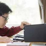 Người đàn ông đang kiểm tra máy in gặp lỗi in ký tự ngẫu nhiên sau cập nhật Windows