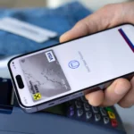 Người đàn ông dùng Apple Pay trên iPhone tại quầy giao dịch, thể hiện sự tiện lợi nhưng tiềm ẩn rủi ro về dữ liệu cá nhân