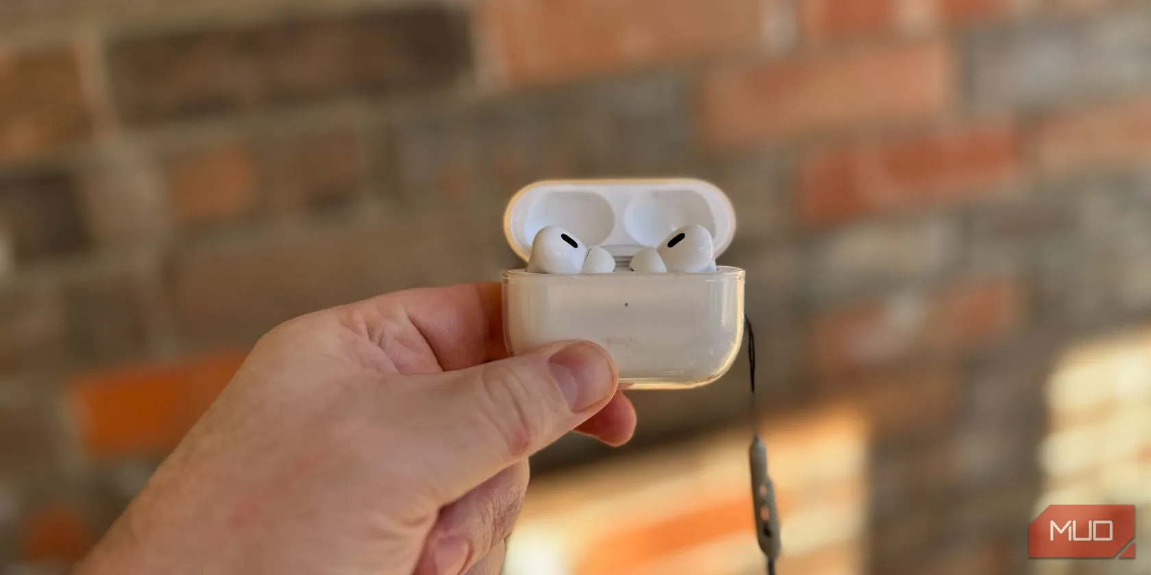 Người dùng cầm hộp sạc AirPods Pro 2 màu trắng.
