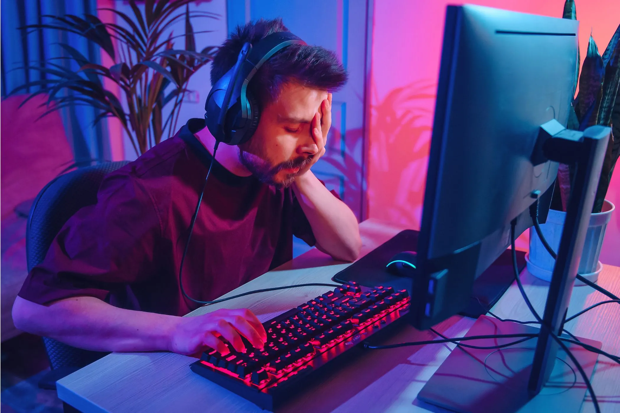 Người dùng thất vọng che mặt trước màn hình máy tính, minh họa sự cố khi PC bị treo hoặc không khởi động được.