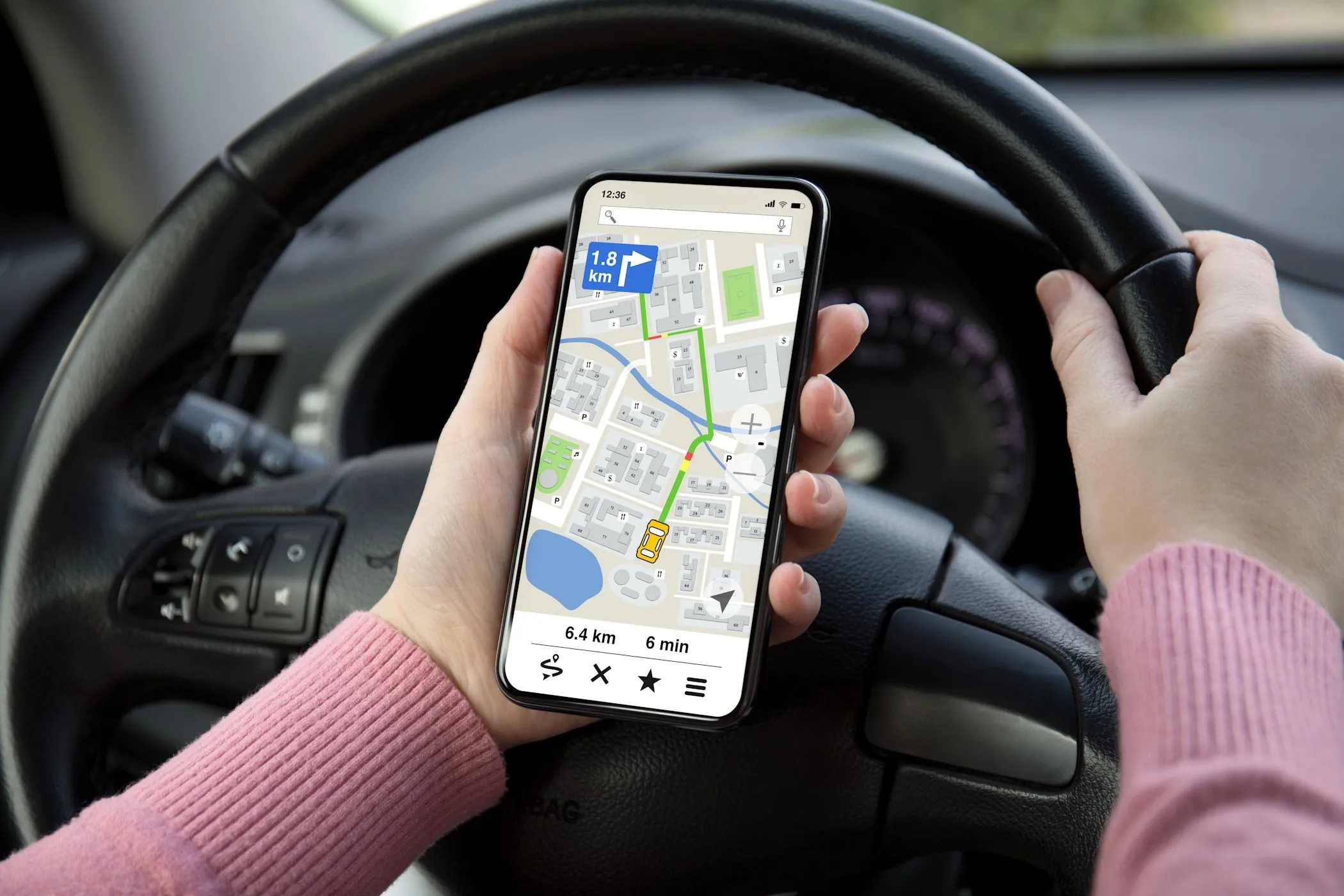 Người phụ nữ đang sử dụng ứng dụng bản đồ trên điện thoại Android trong ô tô để định vị.