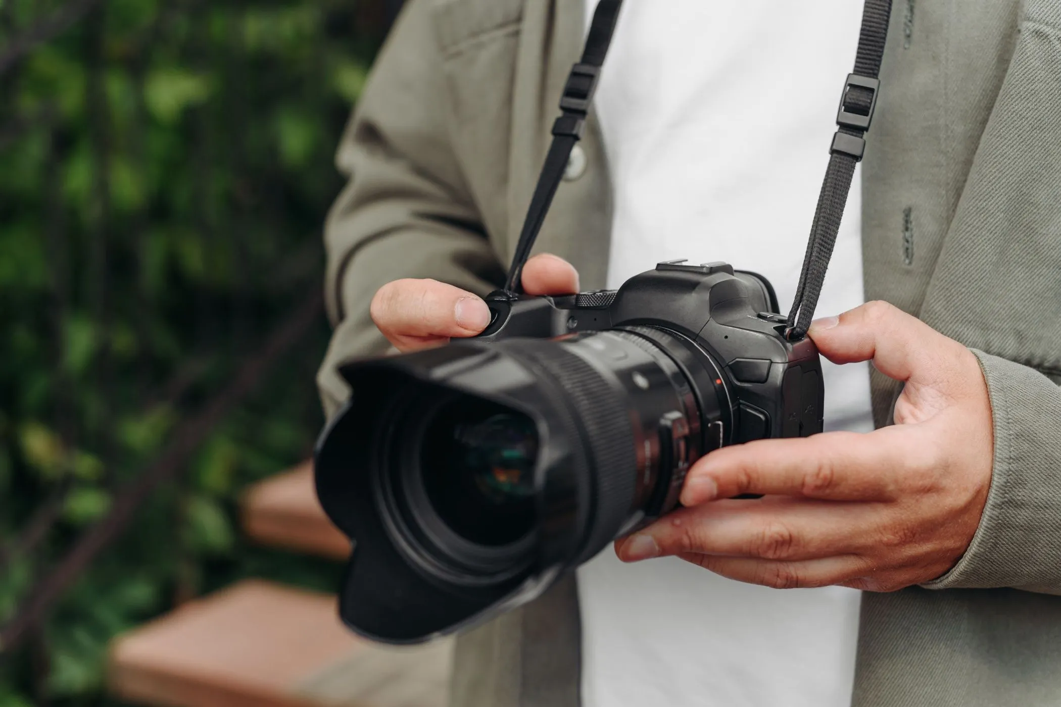 Nhiếp ảnh gia trẻ tuổi cầm máy ảnh DSLR trong môi trường tự nhiên
