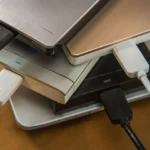 Nhiều ổ đĩa SSD và HDD rời trên bàn làm việc cùng laptop