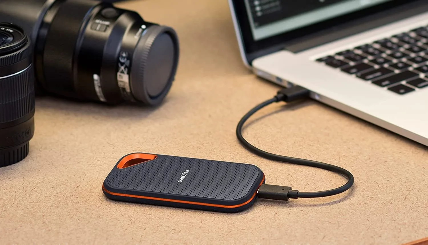 Ổ cứng di động SanDisk Extreme Pro SSD được cắm vào laptop qua cáp USB, dùng để sao lưu dữ liệu.