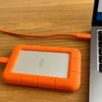 Ổ cứng gắn ngoài được kết nối với máy tính xách tay, thể hiện việc sao lưu dữ liệu.