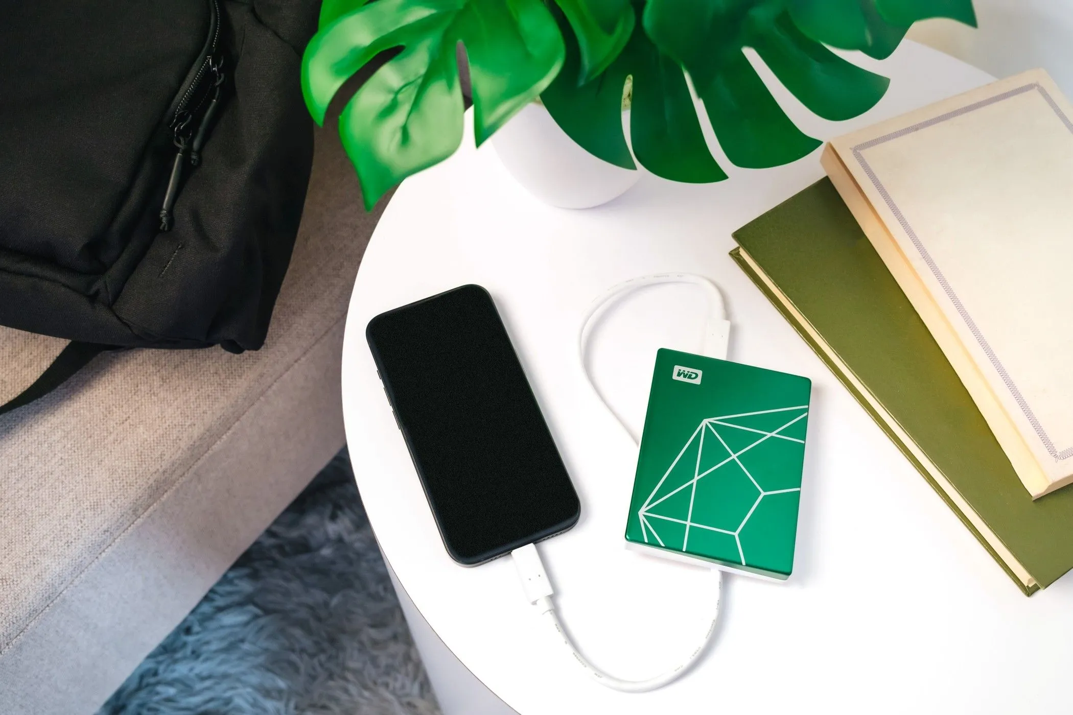 Ổ cứng My Passport Ultra 20th Anniversary Edition kết nối với điện thoại di động trên bàn, minh họa khả năng tương thích USB-C đa dạng