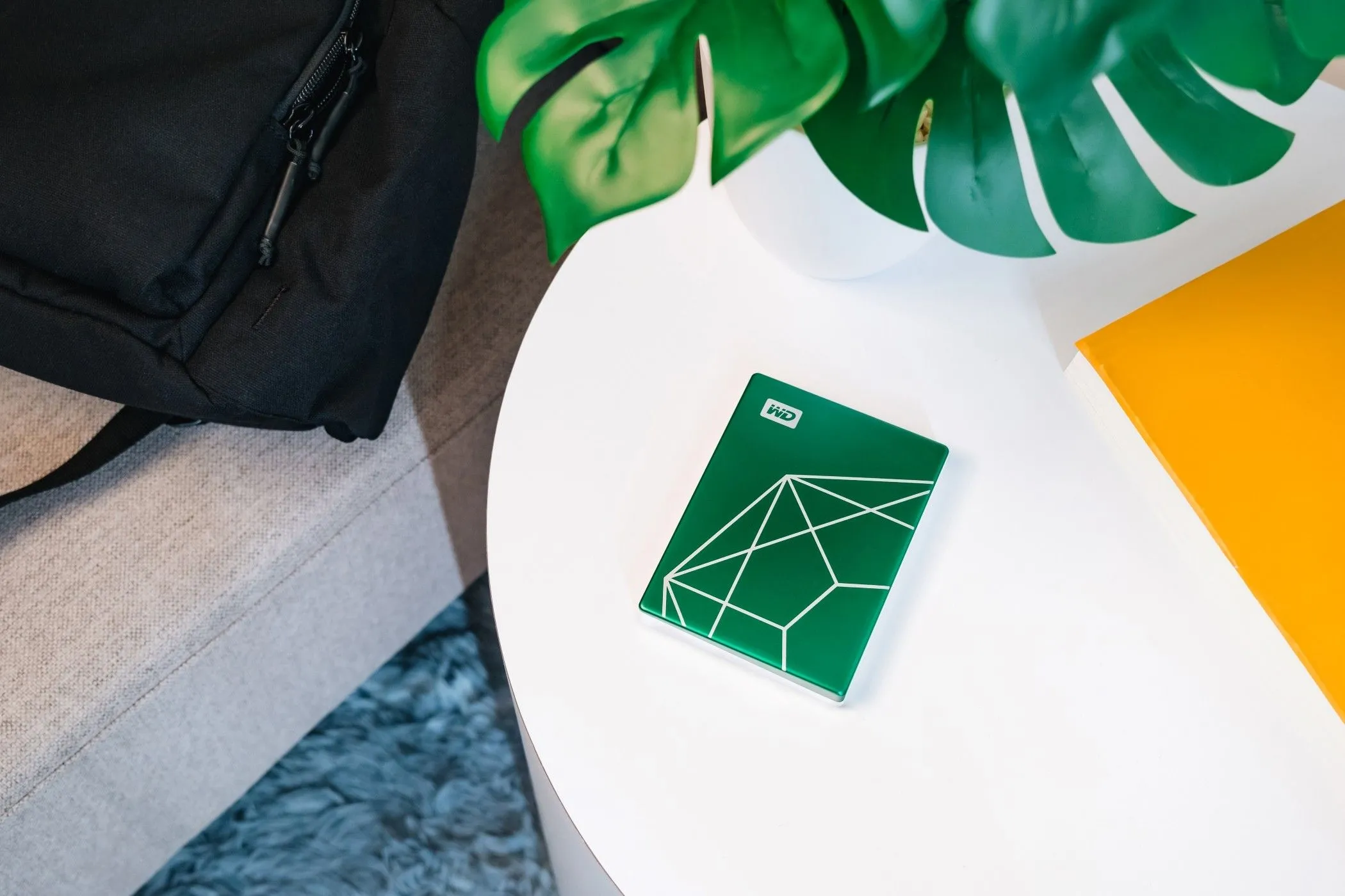 Ổ cứng WD My Passport 20th Anniversary Edition đặt trên mặt bàn, thể hiện cam kết sử dụng vật liệu thân thiện môi trường