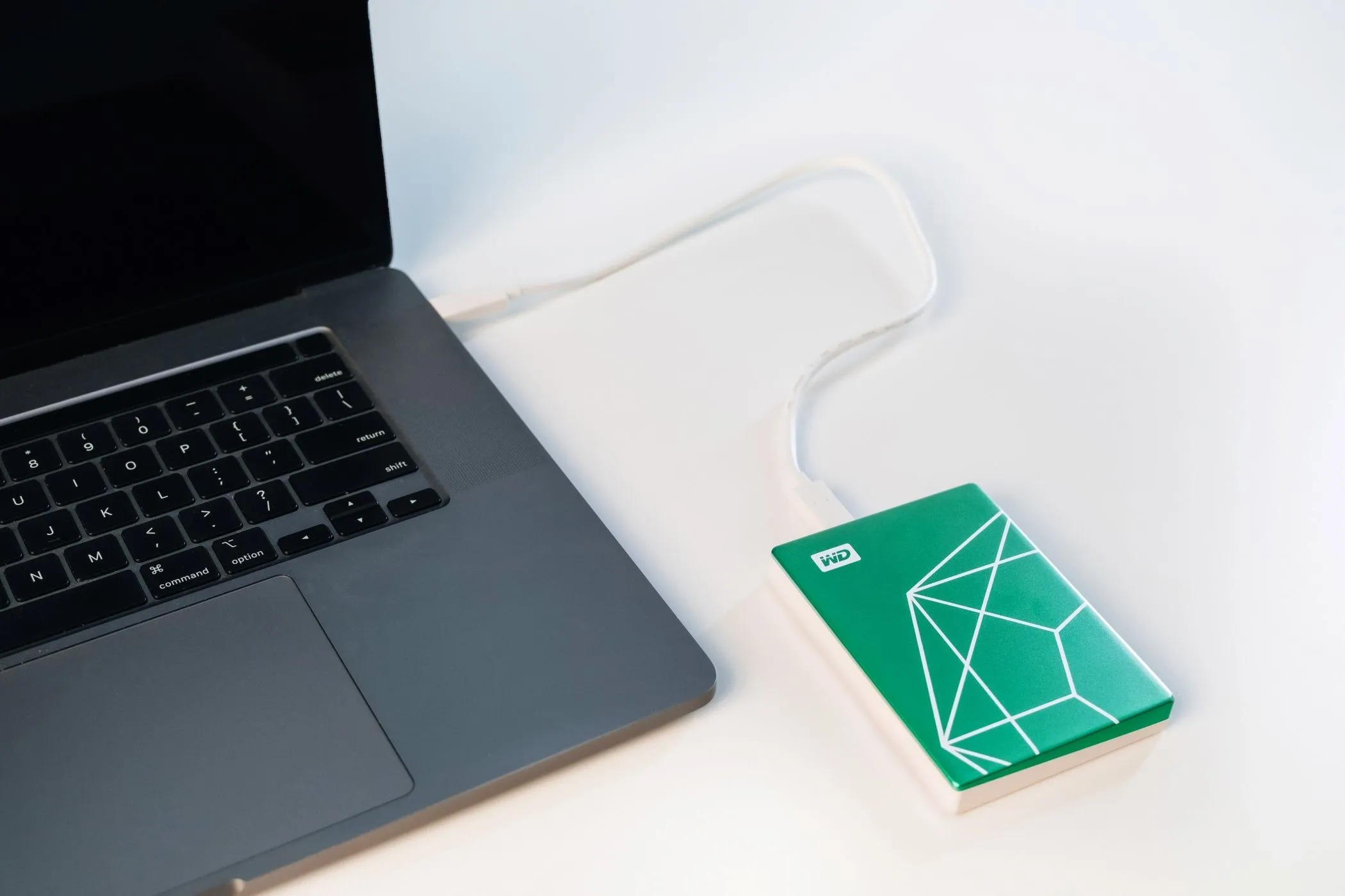 Ổ cứng WD My Passport Ultra Emerald Edition kết nối với máy tính xách tay, cho thấy khả năng sao lưu và bảo vệ dữ liệu dễ dàng