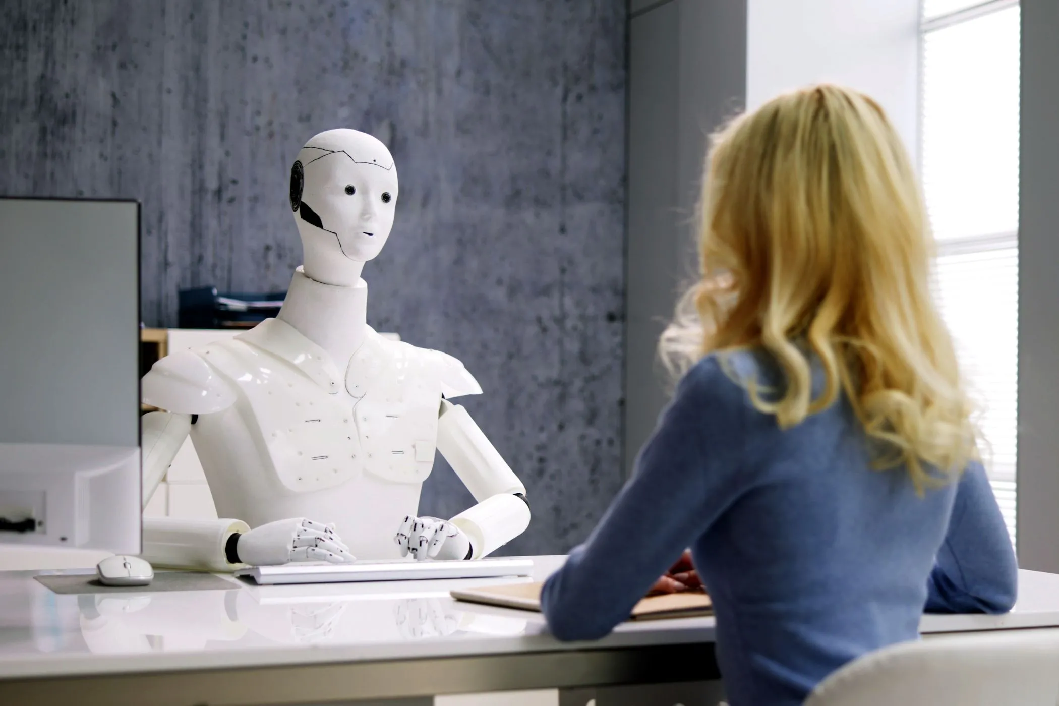 Phụ nữ phỏng vấn robot AI, minh họa tương lai tự động hóa với đại lý AI