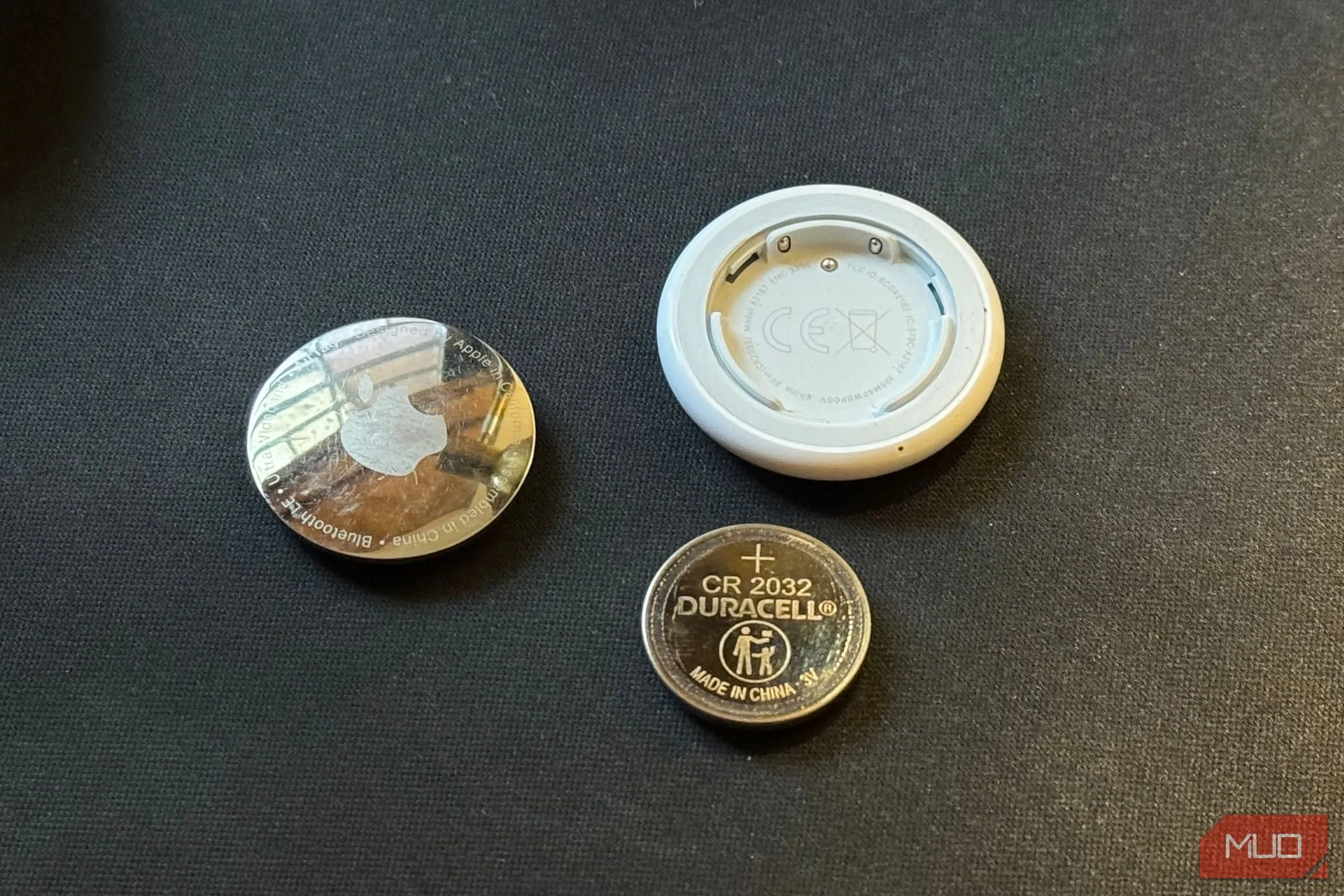 Pin CR2032 của Apple AirTag nằm cạnh thiết bị đã được tháo rời