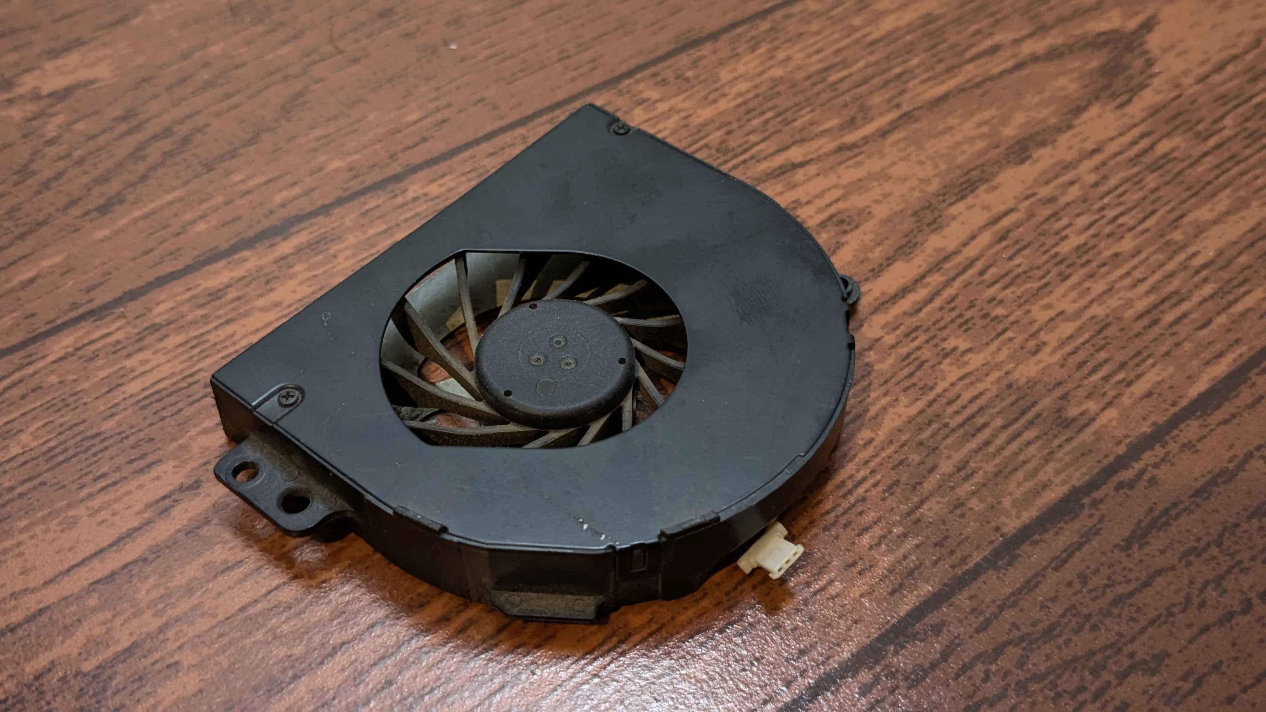 Quạt tản nhiệt của laptop đang hoạt động trên bàn, biểu thị sự làm việc của hệ thống tản nhiệt và tiếng ồn có thể tạo ra.