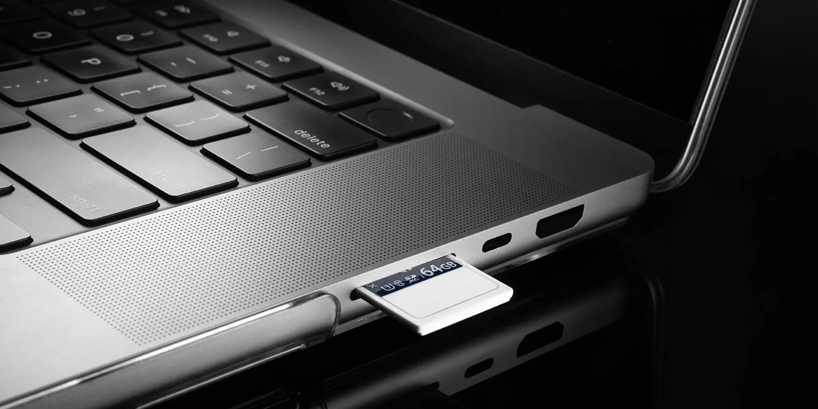 Thẻ nhớ SD đang được lắp vào khe cắm trên laptop