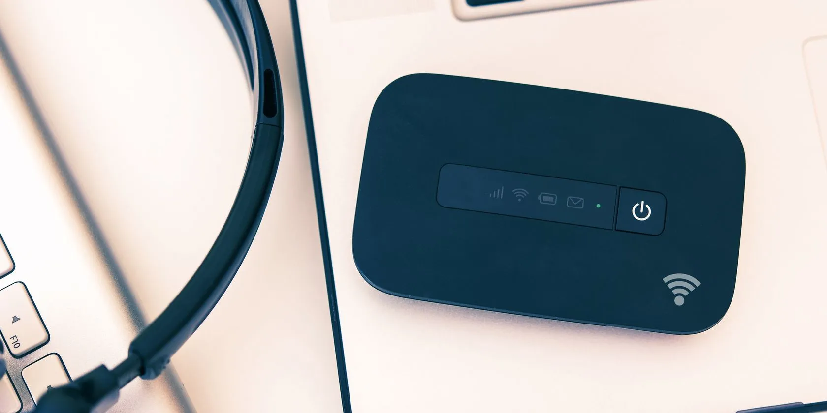 Thiết bị phát Wi-Fi di động đặt cạnh laptop, hỗ trợ kết nối internet ổn định