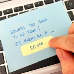 Tờ giấy cảnh báo lừa đảo đặt trên bàn phím máy tính xách tay, thể hiện sự cẩn trọng khi giao dịch trực tuyến